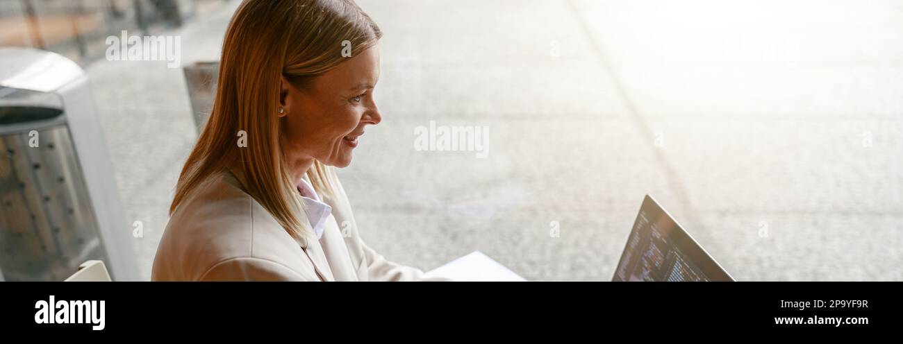 Femme indépendante de programme travaillant sur ordinateur portable tout en étant assise dans un café. Données correctes Banque D'Images