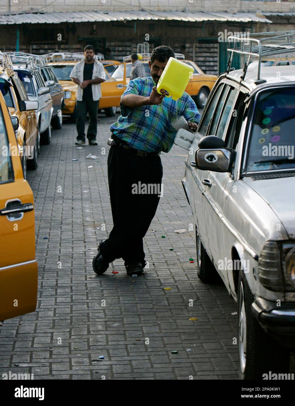A Palestinian man fills up his gas tank with vegetable oil in Gaza City, Wednesday May 21, 2008. Defiant Gaza residents are persistently finding ways around Israeli-imposed fuel restrictions. Owners of gas-run cars are converting to liquid gas. Drivers of old diesel cars use vegetable oil mixes, and two engineers converted a car to run on electrical batteries - and are now open for business. (AP Photo/Tara Todras-Whitehill) Banque D'Images