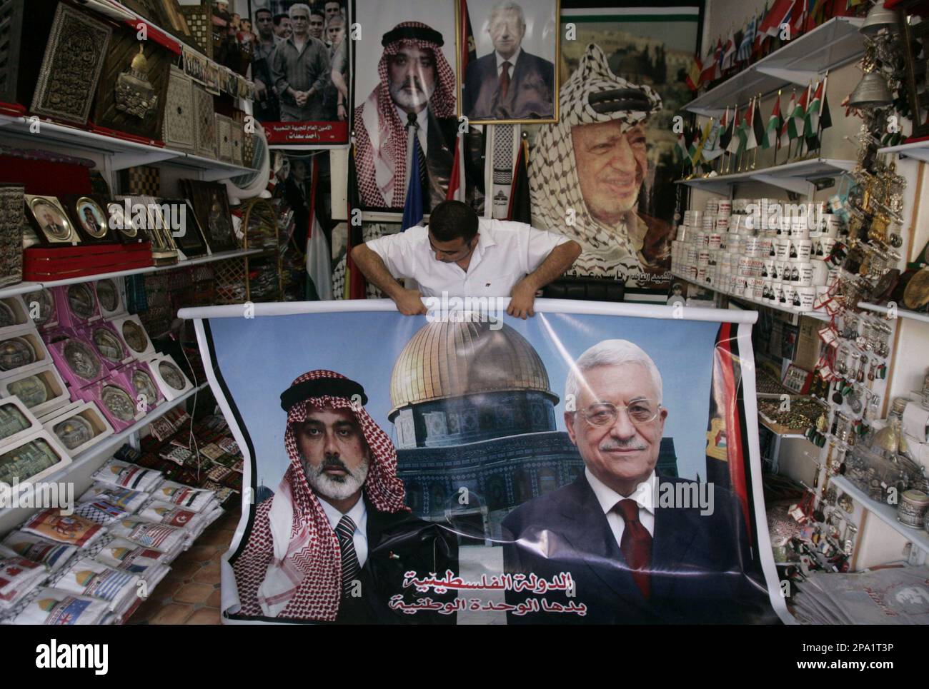 A Palestinian vendor displays a banner showing deposed Palestinian Prime Minister Ismail Haniyeh from Hamas, left, and Palestinian President Mamoud Abbas, right, at his souvenir shop in Gaza City, Monday, June 9, 2008. The militant Palestinian group Hamas is ready for a national Palestinian dialogue that will achieve reconciliation and preserve national rights, the group's leader was quoted as saying Monday. Syria's state-run news agency, SANA, said Hamas' exiled leader Khaled Mashaal made his comments during a meeting Monday with Syria's Foreign Minister Walid al-Moallem. (AP Photo/Khalil Ham Banque D'Images