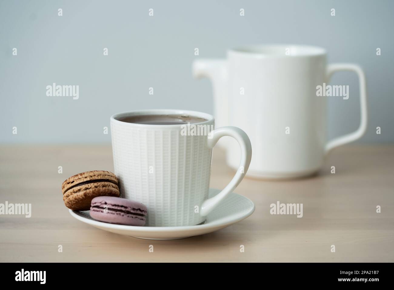 Temps de thé. Tasse de thé avec théière et macaron. Banque D'Images