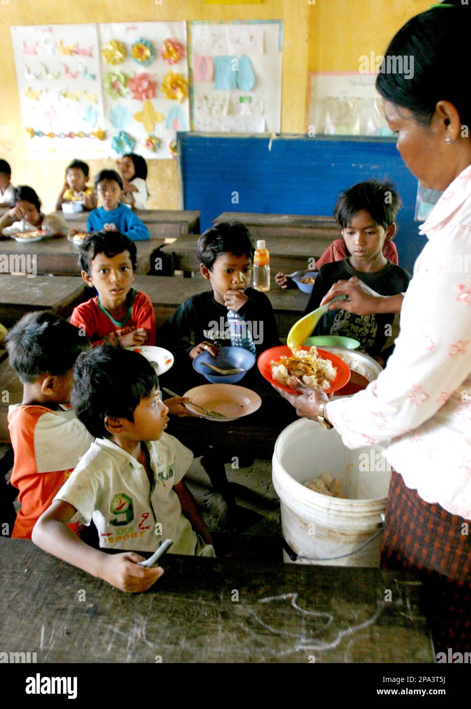 ** HOLD FOR RELEASE ADVANCE FOR SUNDAY, MAY 25**A Cambodian teacher serves rice for her students during a school breakfast, supported by the World Food Program, in Kampong Speu province, about 45 kilometers (28 miles), west of Phnom Penh, Cambodia, April 29, 2008. By the end of the month, the 450,000 Cambodian students who depend on a free breakfast, dished out daily courtesy of the U.N. World Food Program, will become the latest victims of soaring global food prices. (AP Photo/Heng Sinith) Banque D'Images