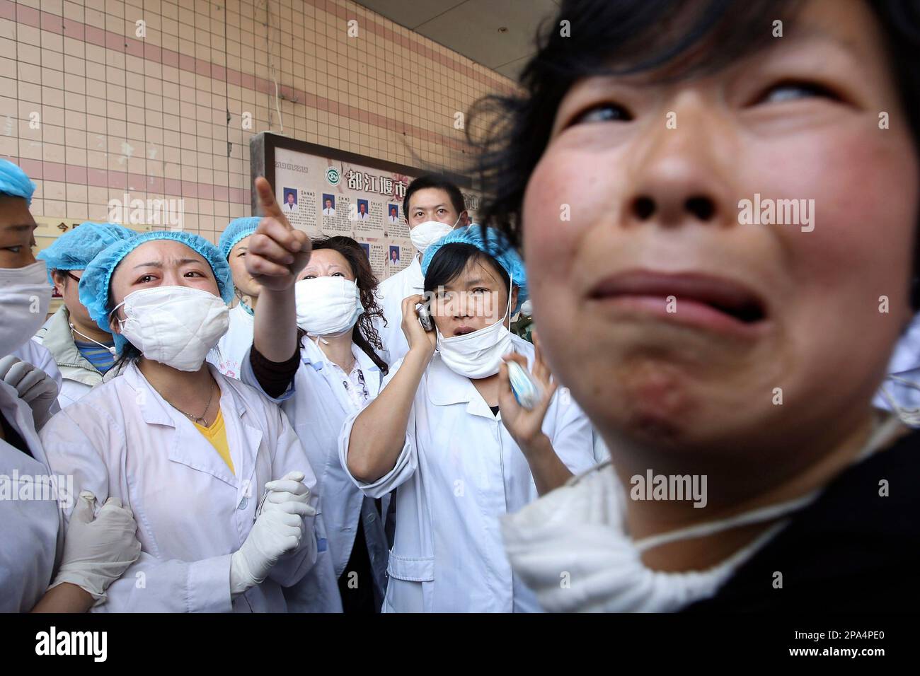 A woman mourns as doctors try to call the trapped victims at a collapsed hospital in earthquake-affected Dujiangyan of southwest China's Sichuan province, Thursday, May 15, 2008. The deadliest earthquake to hit China in decades has killed at least 19,509 people and the toll is likely to rise sharply as tens of thousands more remain buried under debris three days after the Monday tremor. (AP Photo/Color China Photo)**CHINA OUT** Banque D'Images