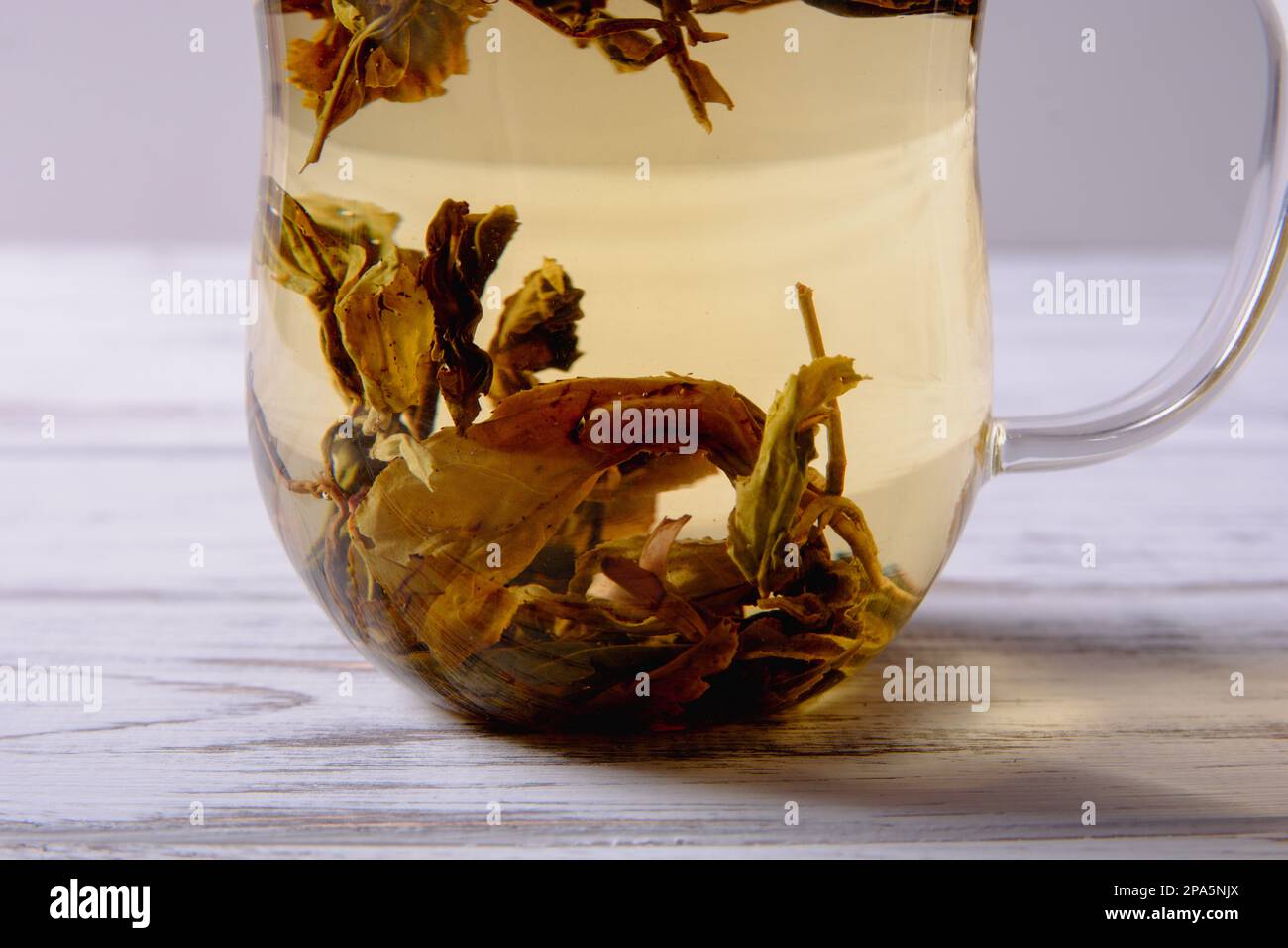 tasse avec thé vert et théière sur fond de table en bois blanc. lumière trop belle Banque D'Images