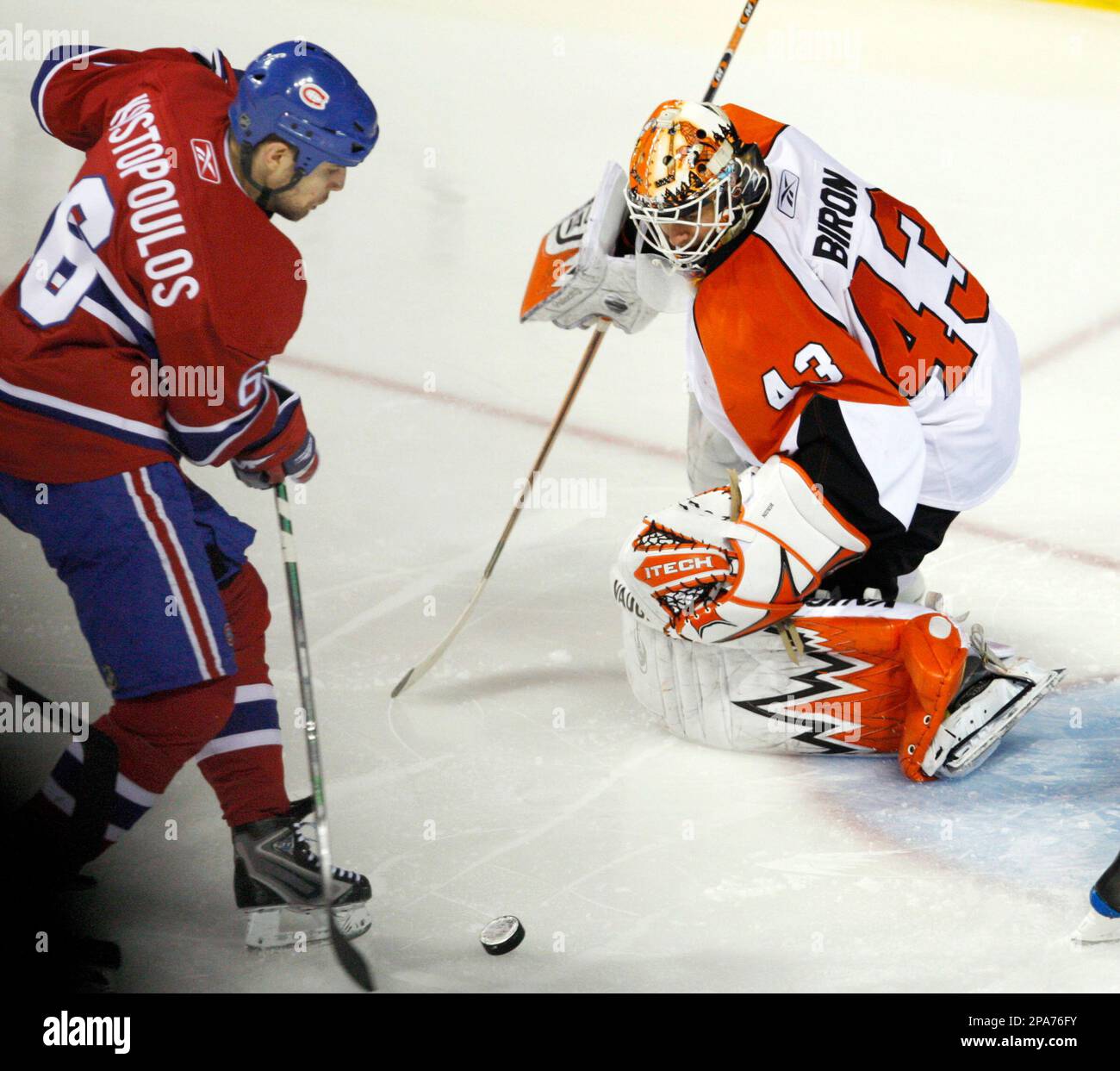 Montreal Canadiens' Tom Kostopoulos, left, scores the winning goal on Philadelphia Flyers goaltender Martin Biron during the first overtime period to win 4-3 in Game 1 of NHL Stanley Cup second-round hockey playoff action in Montreal, Quebec, Thursday April 24, 2008. (AP Photo/The Canadian Press,Ryan Remiorz) Banque D'Images