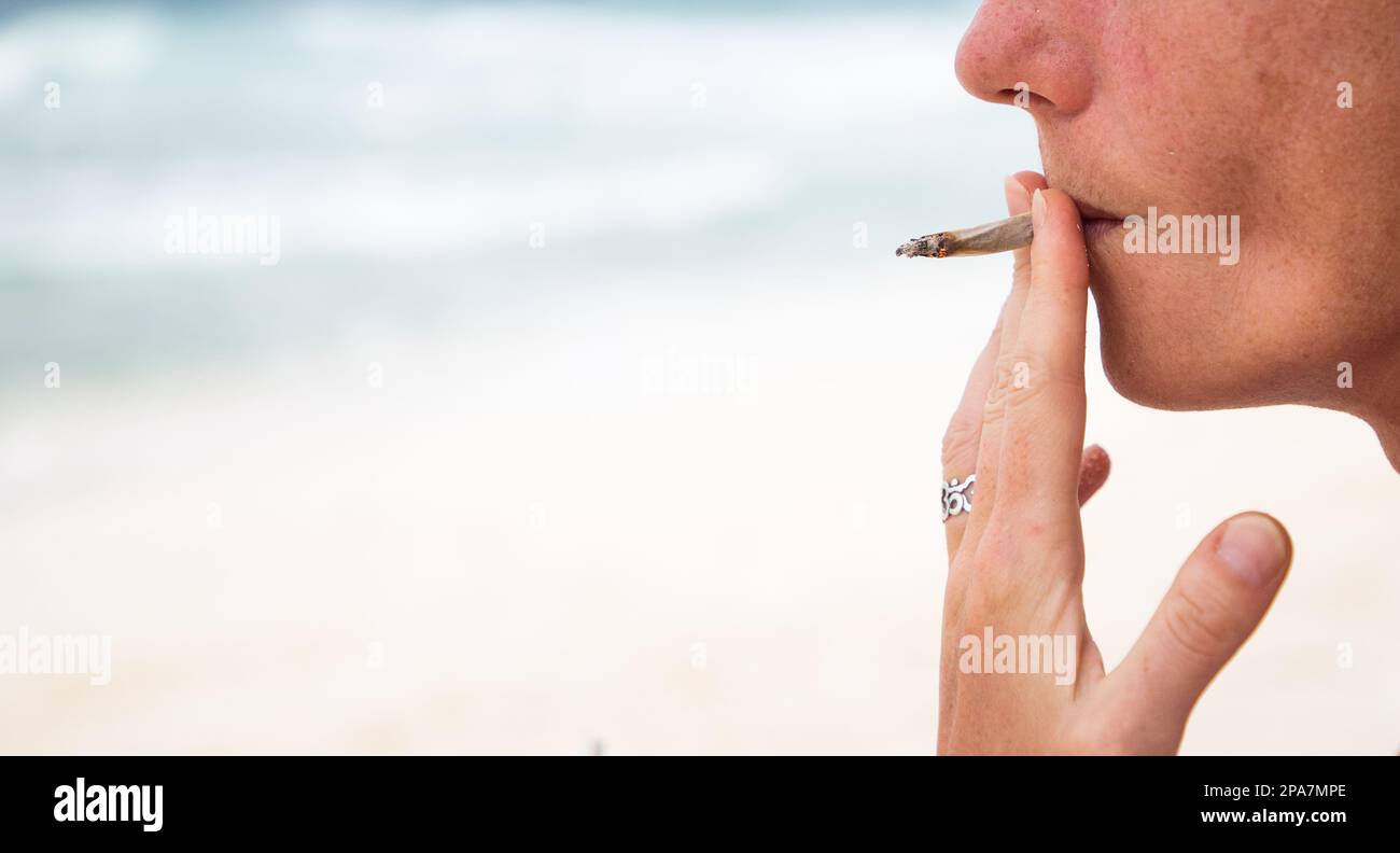 femme fumant un joint sur la plage Banque D'Images