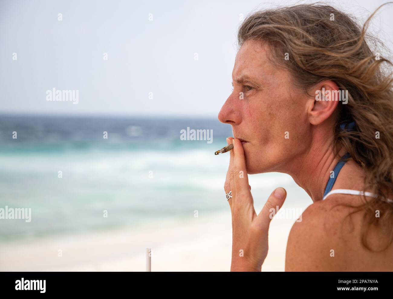 femme fumant un joint sur la plage Banque D'Images