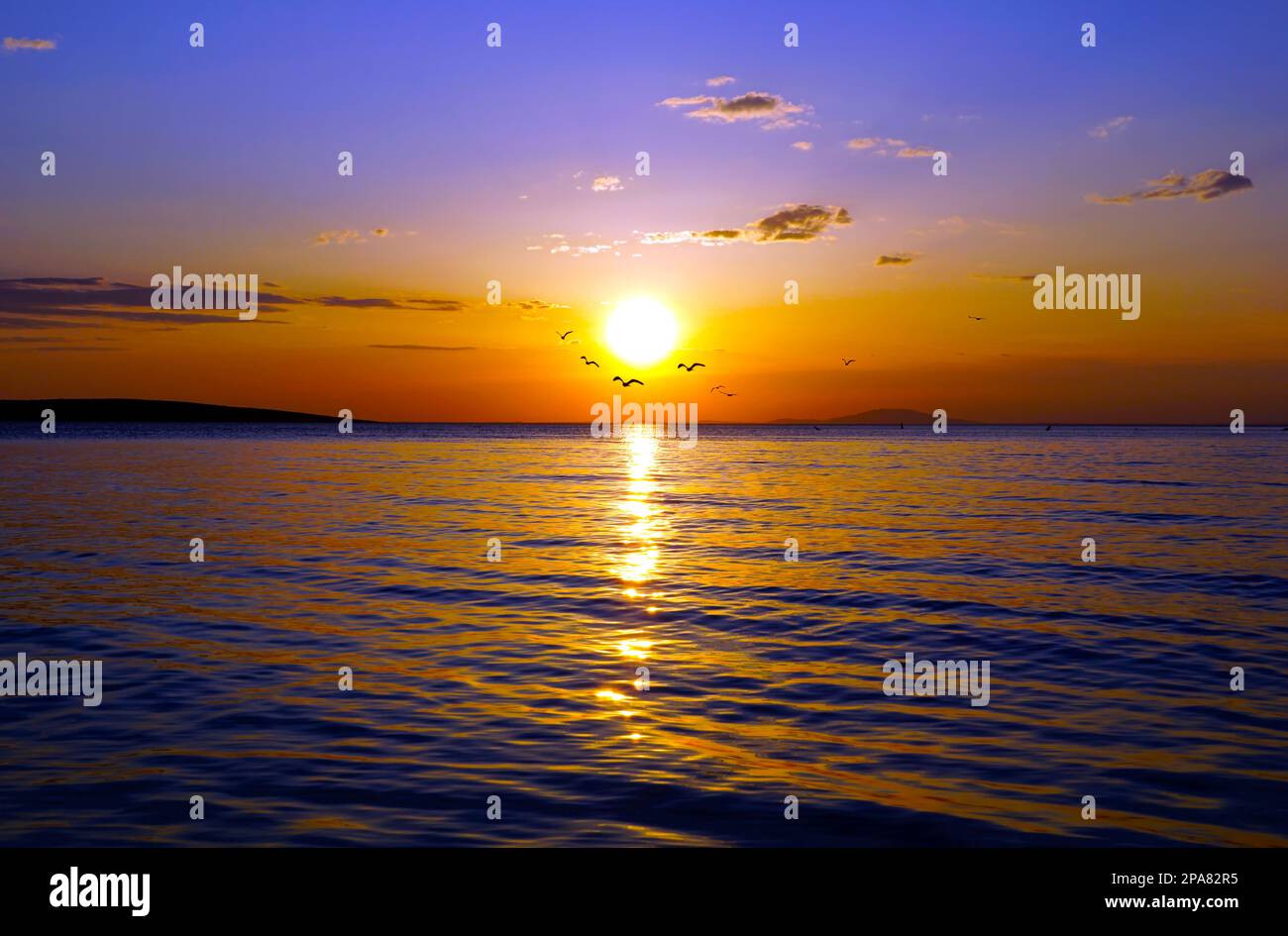 Coucher de soleil de couleur intense sur le ciel bleu avec des nuages au-dessus de la mer ondulée pumplistée vue aérienne Banque D'Images