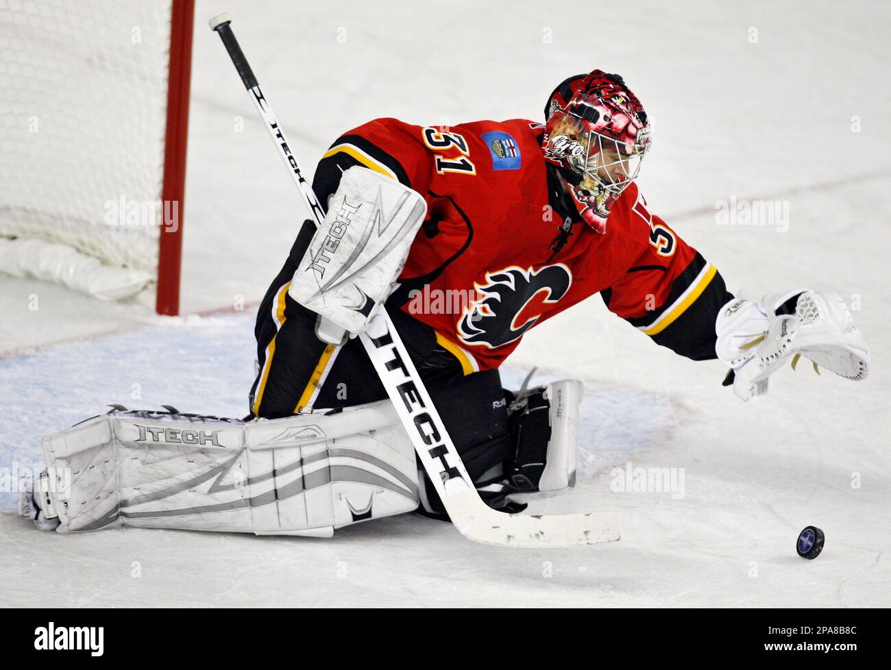 Calgary Flames goalie Curtis Joseph reaches for the puck during the second period of an NHL Western Conference playoff series game in Calgary, Alberta, Sunday, April 13, 2008. The Flames beat the Sharks 4-3 to take the lead in the best of seven series 2-1. (AP Photo/The Canadian Press, Jeff McIntosh) Banque D'Images