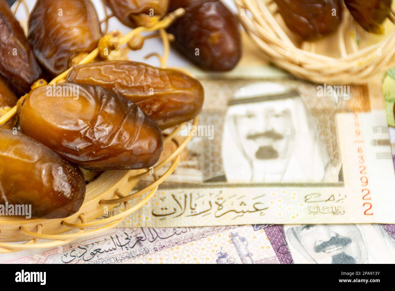 Gros plan des dates royales algériennes sur une plaque en bois. Billets d'argent de l'Arabie Saoudite. Concept de Ramadan. Banque D'Images