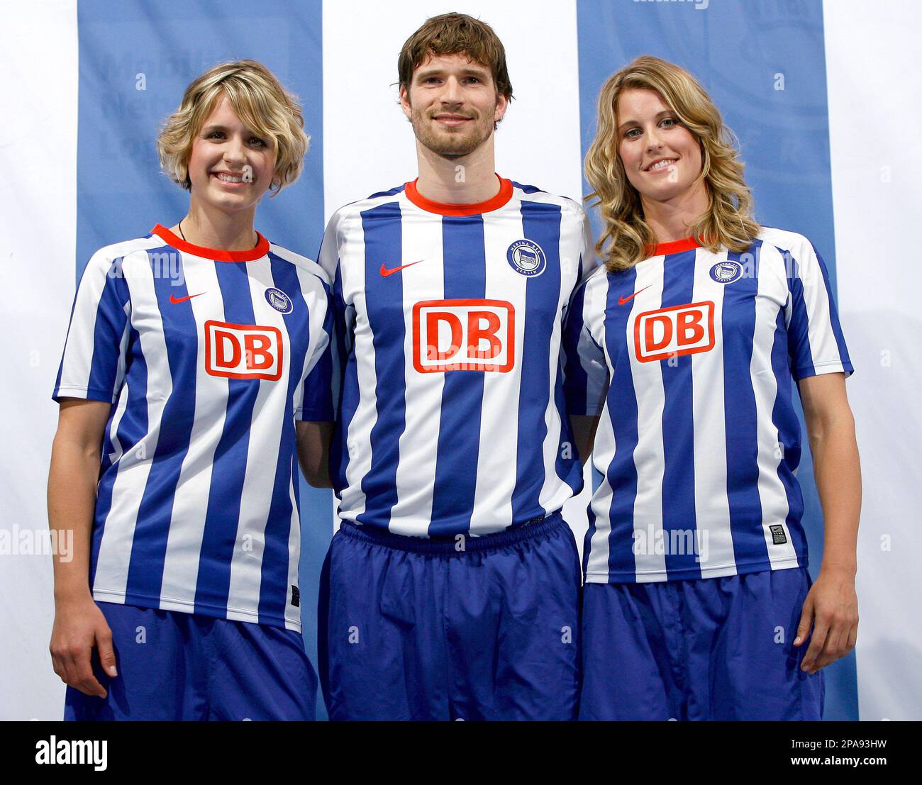 Player Arne Friedrich, center, and the beach volleyball players of Hertha, Laura Ludwig, left, and Sara Goller, right, present the new jersey for the season 2008/09 of the German first division Bundesliga soccer club Hertha BSC Berlin in Potsdam near Berlin, Germany, Monday, April. 7, 2008. (AP Photo/Michael Sohn) Banque D'Images