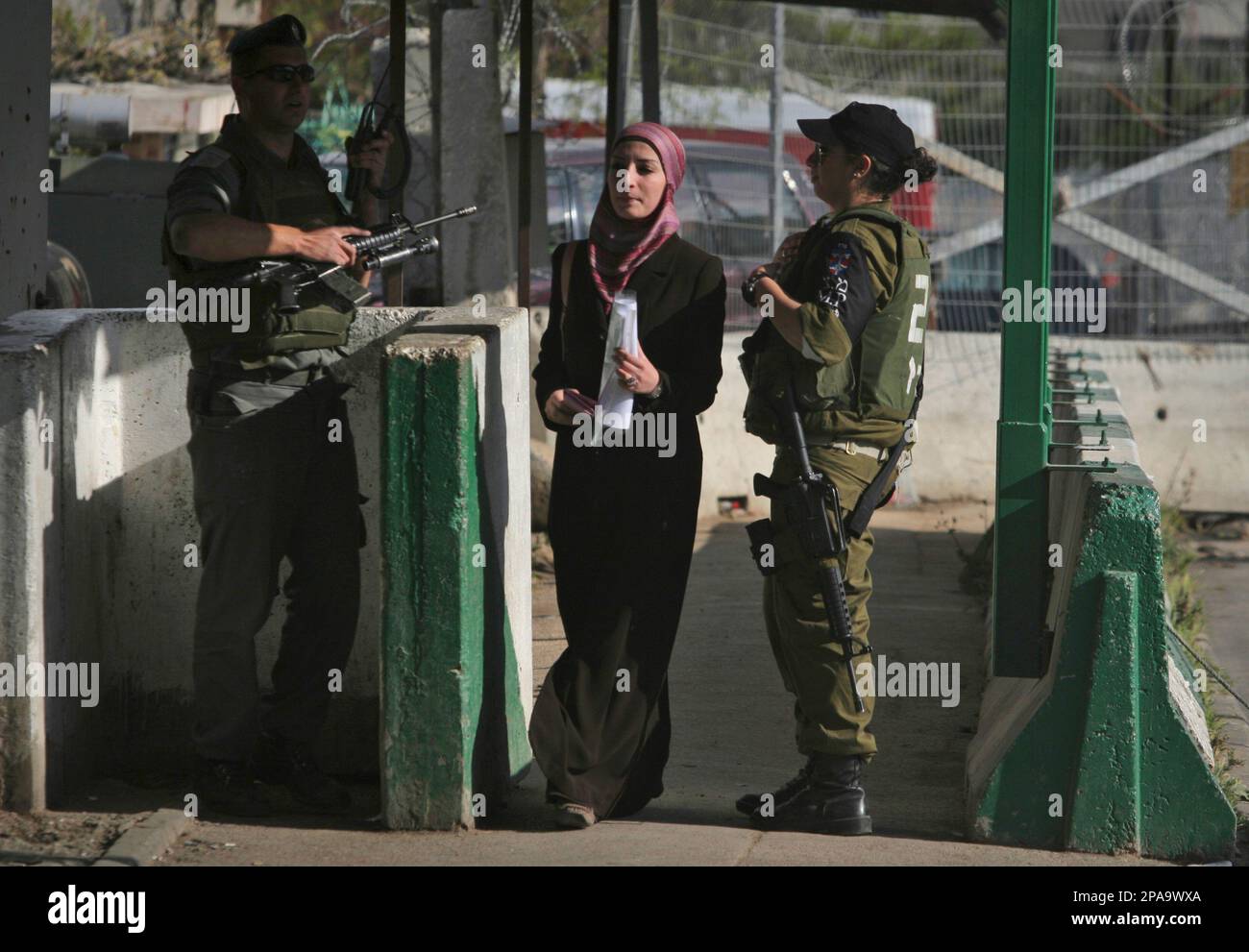 A Palestinian woman walks through an Israeli military checkpoint in the West Bank village of A-Ram, in the northern outskirts of Jerusalem, Monday, March 31, 2008. U.S. Secretary of State Condoleezza Rice met Monday morning with the chief negotiators, former Palestinian Prime Minister Ahmed Qureia and Israeli Foreign Minister Tzipi Livni. Talks with the sides a day earlier produced Israeli promises to ease restrictions in the West Bank.(AP Photo/Dan Balilty) Banque D'Images