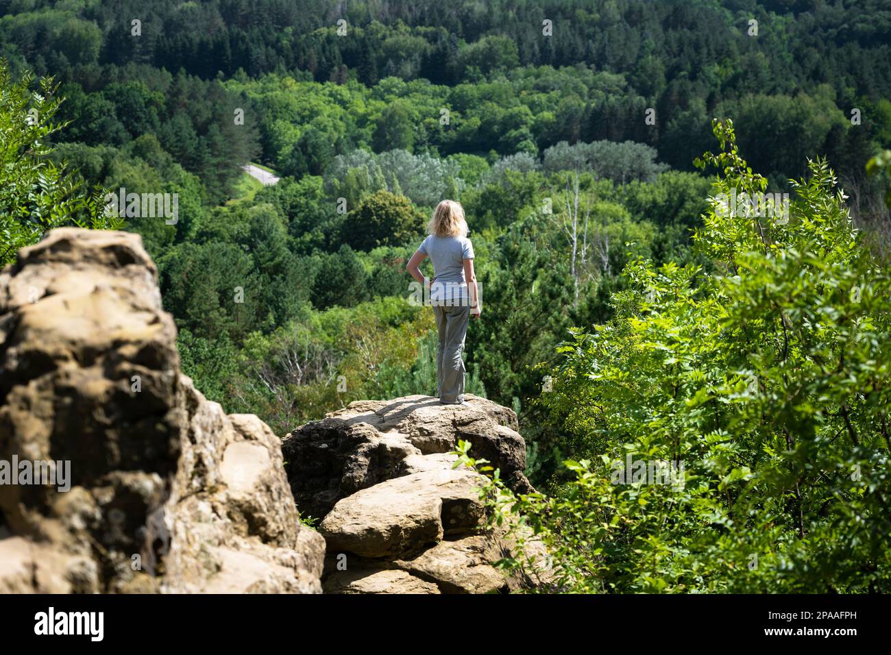 Femme touriste se tient sur le rocher dans le parc de la station, Kislovodsk, Russie. Paysage avec montagnes et forêt en été. Thème de randonnée, voyage à Stavropol Banque D'Images