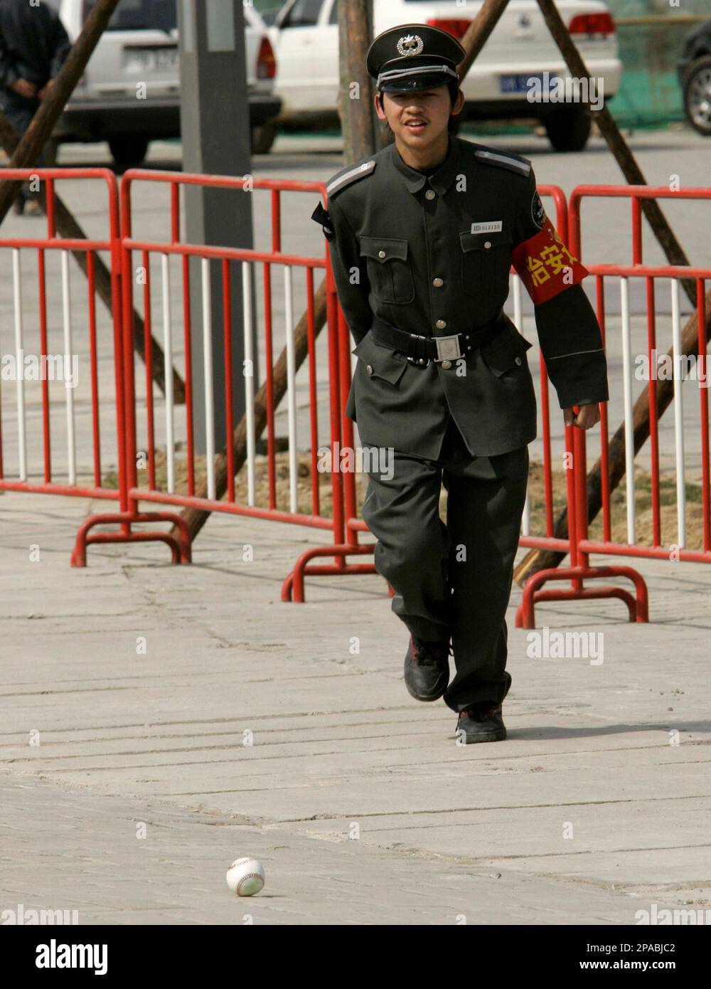 A Chinese security guard chases a baseball after it was hit over the leftfield fence at Wukesong Baseball Field during the San Diego Padres' batting practice before an exhibition game against the Los Angeles Dodgers, Sunday, March 16, 2008, in Beijing, China. (AP Photo/Robert F. Bukaty) Banque D'Images