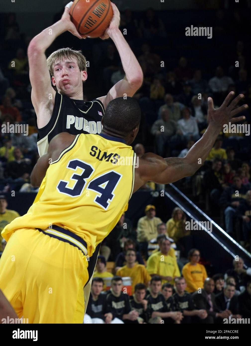 Purdue guard Robbie Hummel, back, looks to pass the ball while defended by Michigan forward DeShawn Sims (34) in the first half of a college basketball game, Sunday, March 9, 2008, in Ann Arbor, Mich. (AP Photo/Tony Ding) Banque D'Images