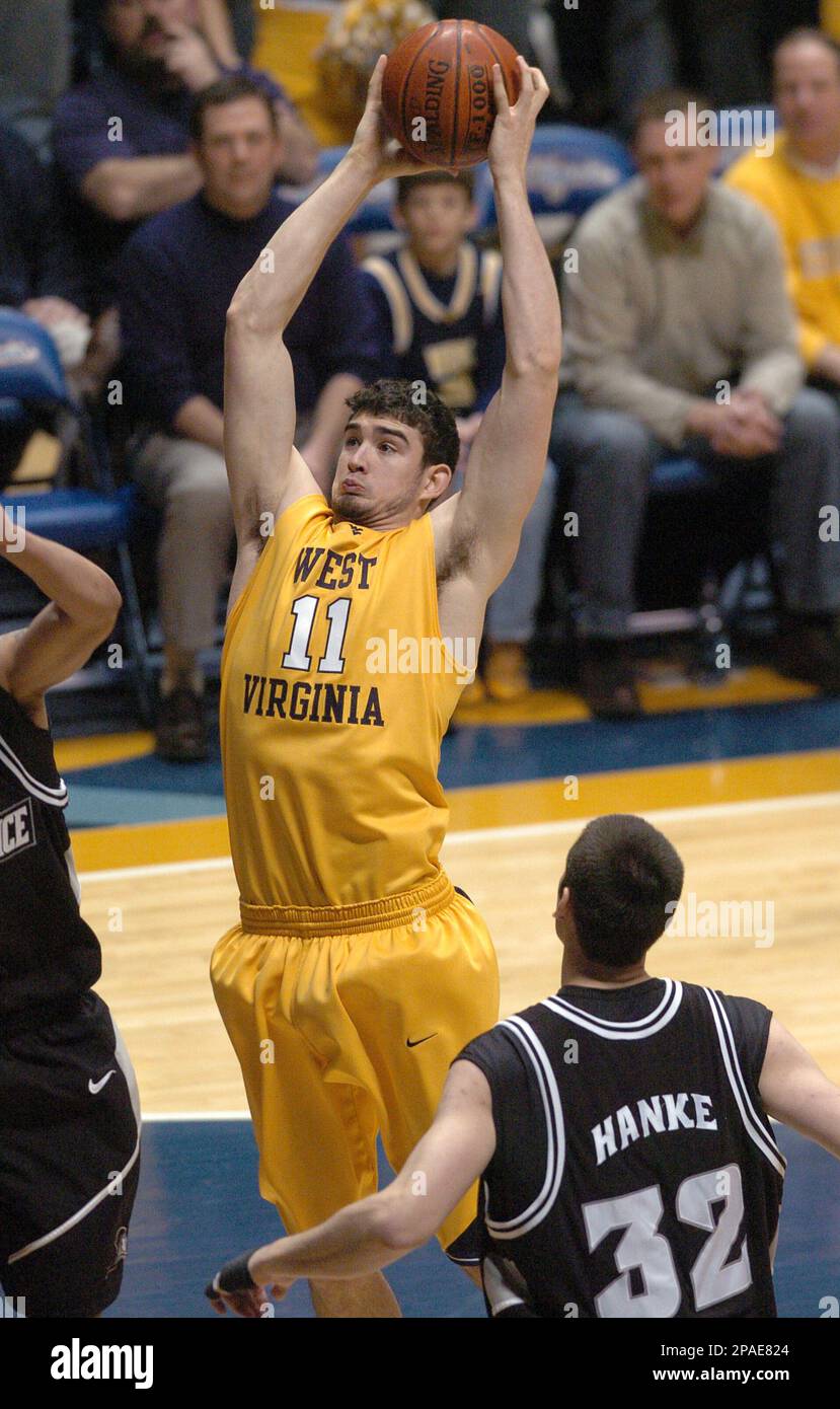 West Virginia's Joe Alexander, center, pulls down a rebound over  Providence's Jeff Xavier, left, and Randall Hanke, right, during the first  half of a college basketball game Saturday, Feb 23, 2008, in