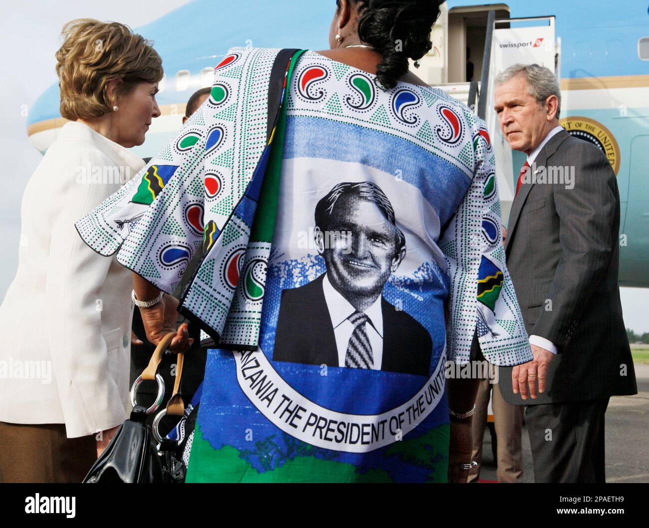 Tanzania's President Jakaya Mrisho Kikwete, rear center obscured, and his wife Salma, center, who is wearing "kanga" (traditional African cloth) bearing the image of U.S. President George. W. Bush, bid farewell to President Bush and First Lady Laura Bush, at the steps of Air Force One, at Julius Nyerere International Airport in Dar es Salaam, Tanzania, Tuesday, Feb. 19, 2008. (AP Photo/Charles Dharapak) Banque D'Images