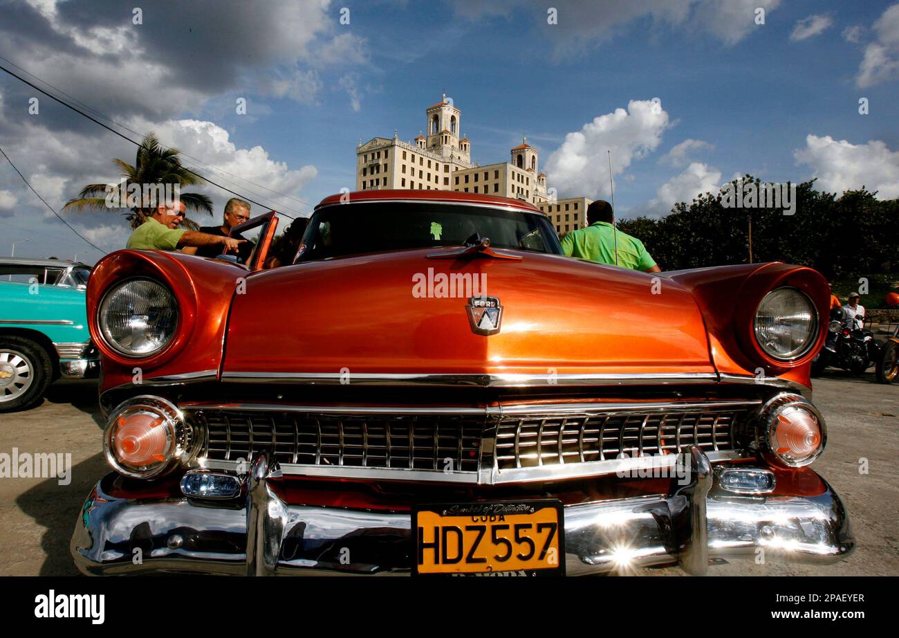 Two men look at an old classic American car during an event honoring Argentina's late racing driver Juan Manuel Fangio in Havana Sunday, Feb. 17, 2008. Juan Manuel Fangio was a race car driver from Argentina, who dominated the first decade of Formula One racing. He won five Formula One World Driver's Championships with four different teams: Alfa Romeo, Ferrari, Mercedes-Benz and Maserati (AP Photo/Javier Galeano) Banque D'Images