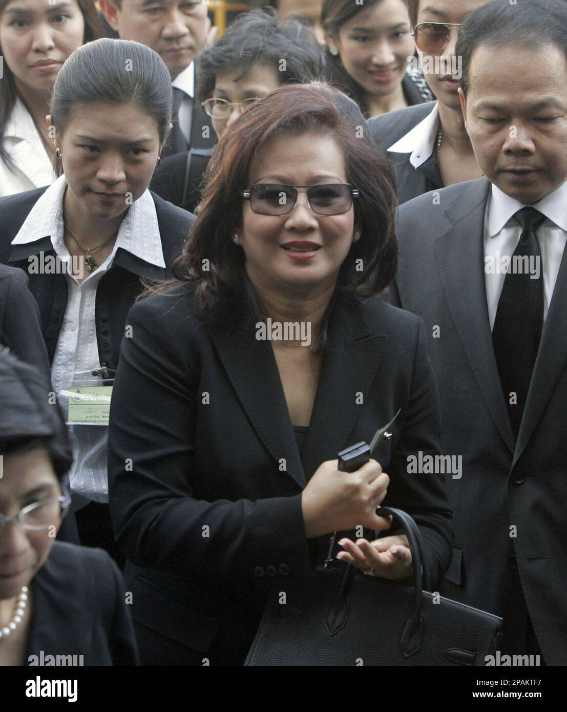Flank by family members and legal team, Pojamarn Shinawatra, center, proceeds to the entrance to Supreme Court in Bangkok, Thailand Tuesday, Jan. 8, 2008. Pojamarn, wife of ousted Prime Minister Thaksin Shinawatra, was arrested after she returned to Thailand on Tuesday to face corruption charges that could put her behind bars for 20 years, police said. She was later released on 5 million baht (US$168,000; euro114,000) bail. (AP Photo/Apichart Weerawong) Banque D'Images