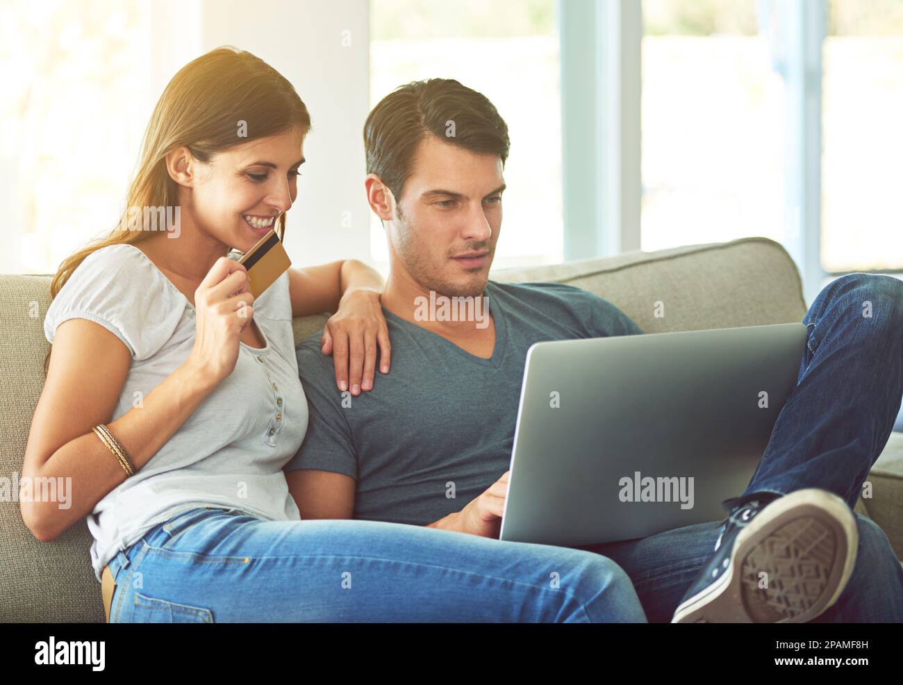 Shopping dans le confort de la maison. un jeune couple faisant des achats en ligne à la maison. Banque D'Images