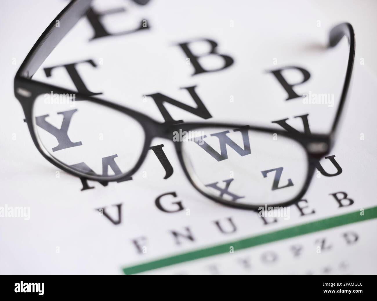 Optométrie, lettre et soins de santé avec des lunettes et un graphique pour la mise au point, la lecture et les tests oculaires. Médical, optique et prescription avec des lunettes sur le texte Banque D'Images