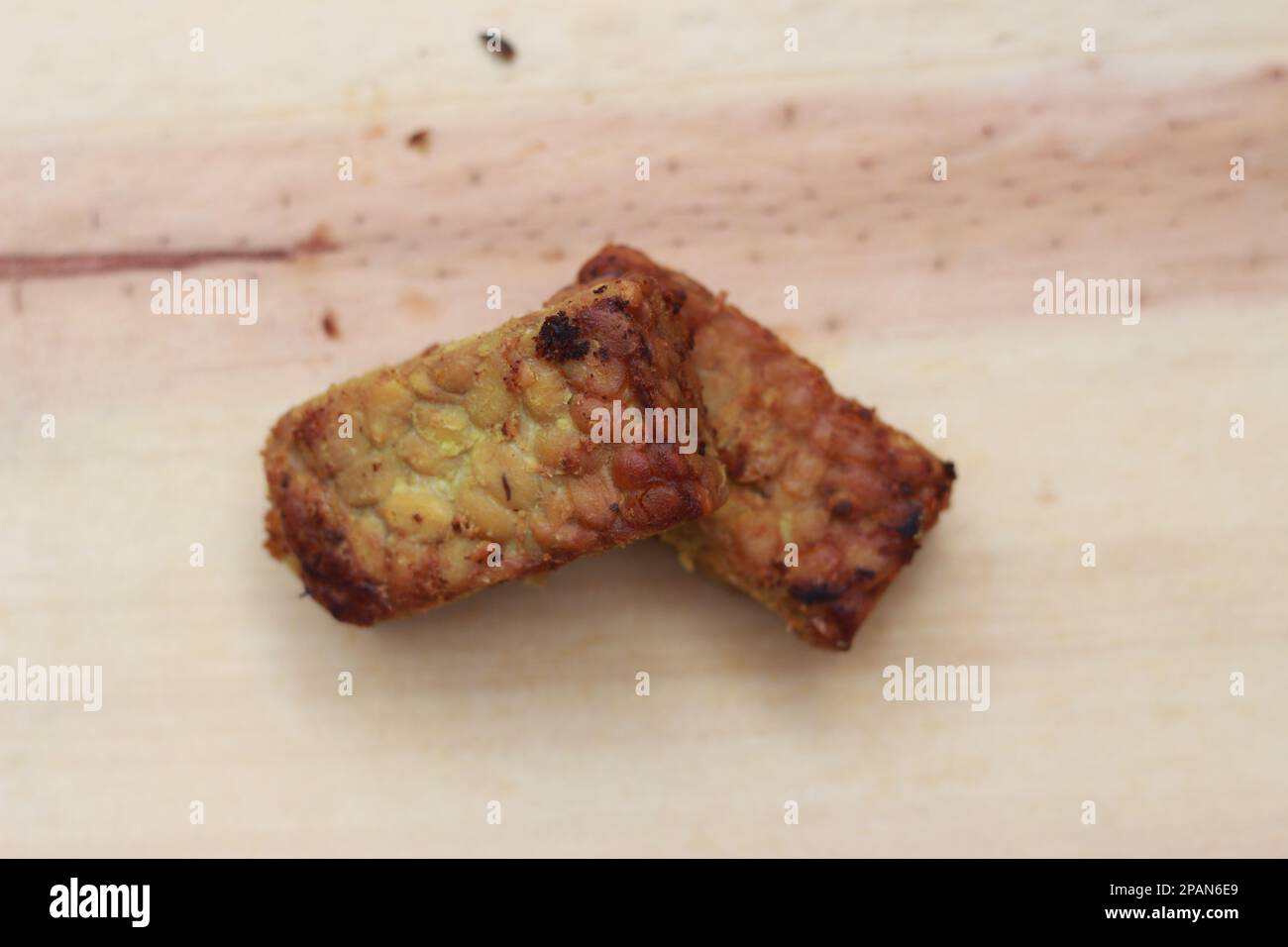 un gros plan de la tempeh frite sur une planche à découper en bois. Concept de la cuisine traditionnelle indonésienne. Banque D'Images
