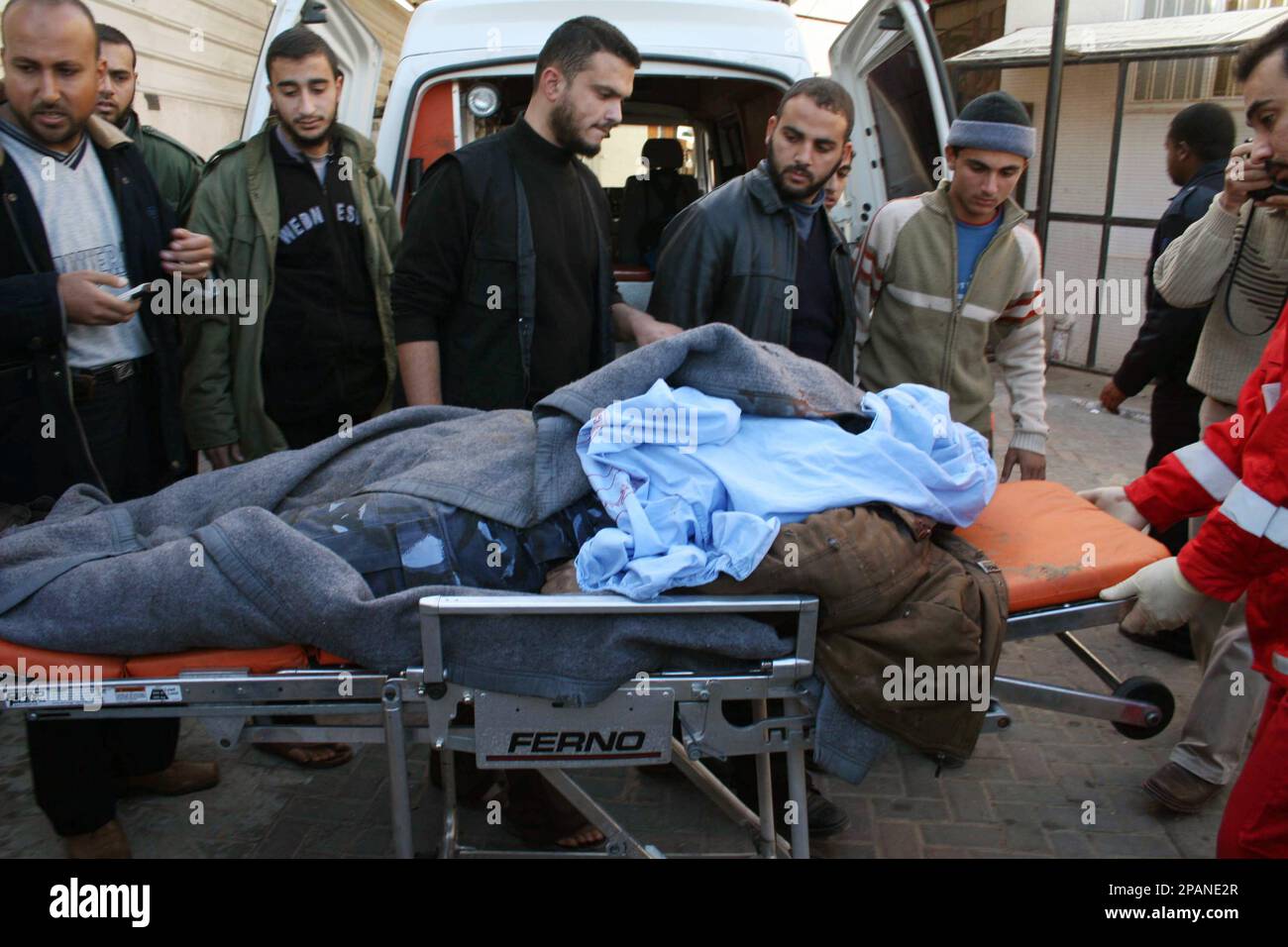 Palestinian medics and relatives wheel the body of a Hamas police officer, killed by an Israeli airstrike, into Al Najar hospital in Rafah southern Gaza Strip, Tuesday, Dec. 18, 2007. Israeli aircraft launched an assault on the radical Islamic Jihad organization from the skies over Gaza late Monday and early Tuesday, killing the group's overall commander and nine other members in three fiery strikes. A fourth attack on a security post in southern Gaza killed two Hamas militants, that group said. (AP Photo) Banque D'Images