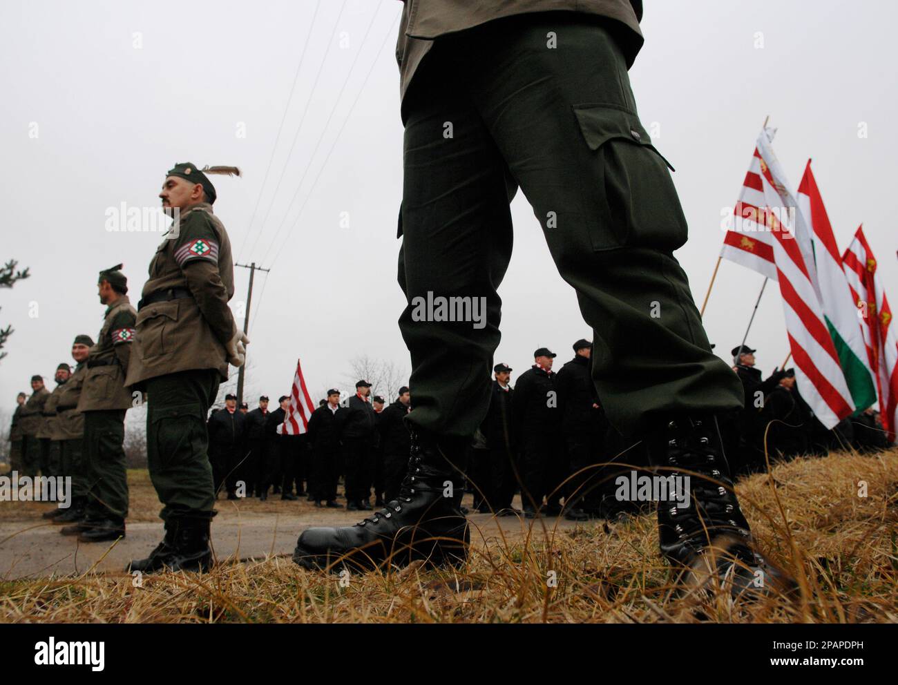 Members of the controversial new right wing "Magyar Garda" or Hungarian guard stand in the village of Tatarszentgyoergy (65 km/40 miles south of Budapest) Hungary, Sunday, Dec. 9, 2007. Magyar Garda members, who wear uniforms bearing a variation on the red-and-white Arpad Stripes associated with Hungary's Nazi-aligned Arrow Cross party of WWII, marched through Tatarszentgyoergy to frighten the village's Gypsy community and they raised fears. Prior to the establishment of the Magyar Garda, Hungarian Jewish and Gypsy organizations have been warning that anti-Semitism was on the rise. (AP Photo/B Banque D'Images