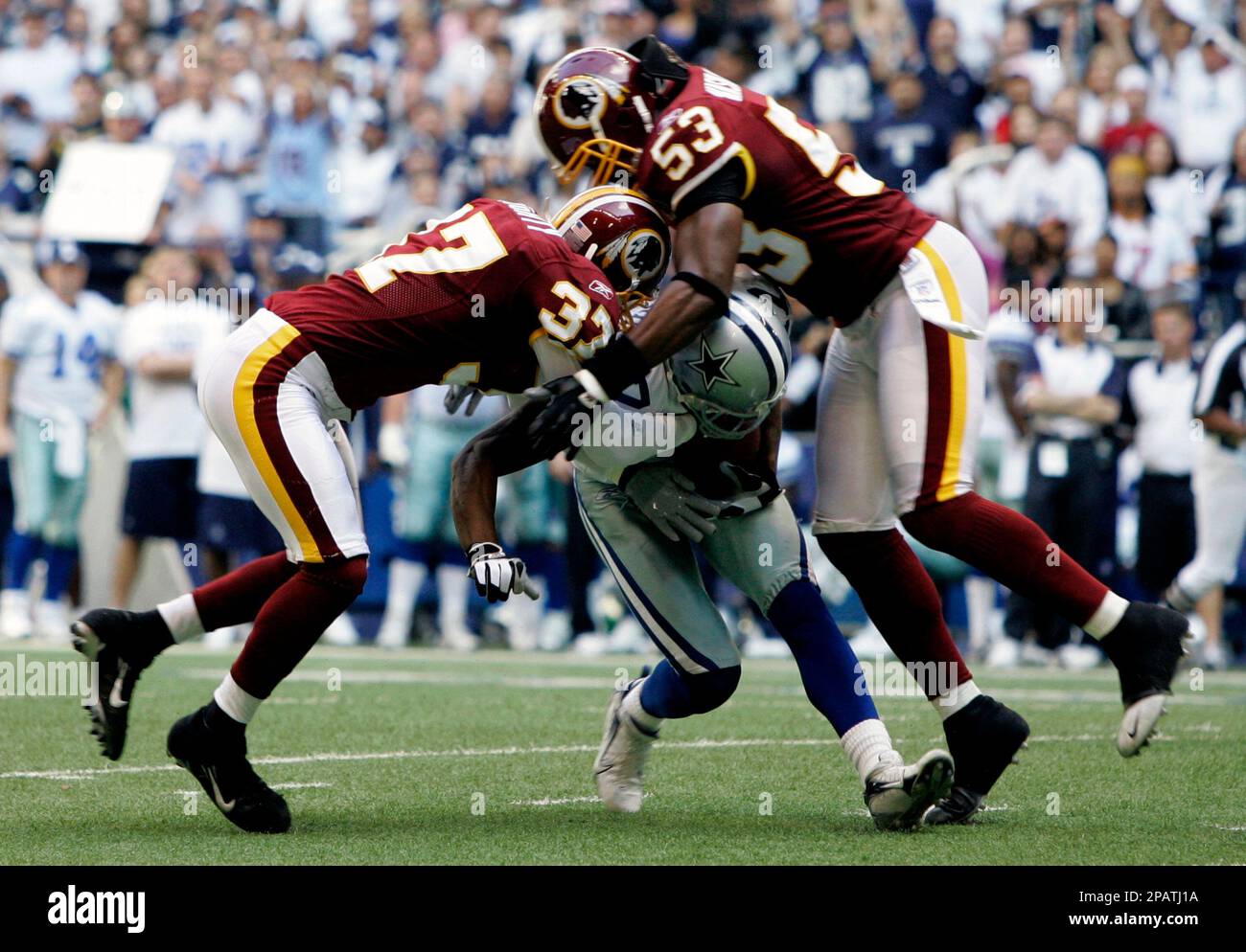 Dallas Cowboys wide receiver Sam Hurd, center, is tackled by Washington Redskins safety Reed Doughty (37) and Washington Redskins linebacker Marcus Washington (53) after picking up 15 yards on a pass play in the first quarter of their NFL football game, Sunday, Nov. 18, 2007, in Irving, Texas. (AP Photo/Tony Gutierrez) Banque D'Images