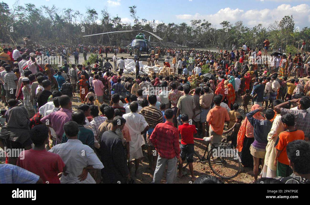 Hundreds of Bangladeshi people affected by Tropical Cyclone Sidr gather as relief supplies are unloaded at Bagerhat in Khulna district, 136 kilometers,(85 miles) south east of Bangladesh's capital Dhaka, Saturday, Nov. 17, 2007. The official death toll from the savage cyclone in Bangladesh reached 1,070 on Saturday as military helicopters and ships joined rescue efforts in the wake of the deadliest storm to hit the country in a decade. (AP Photo) Banque D'Images