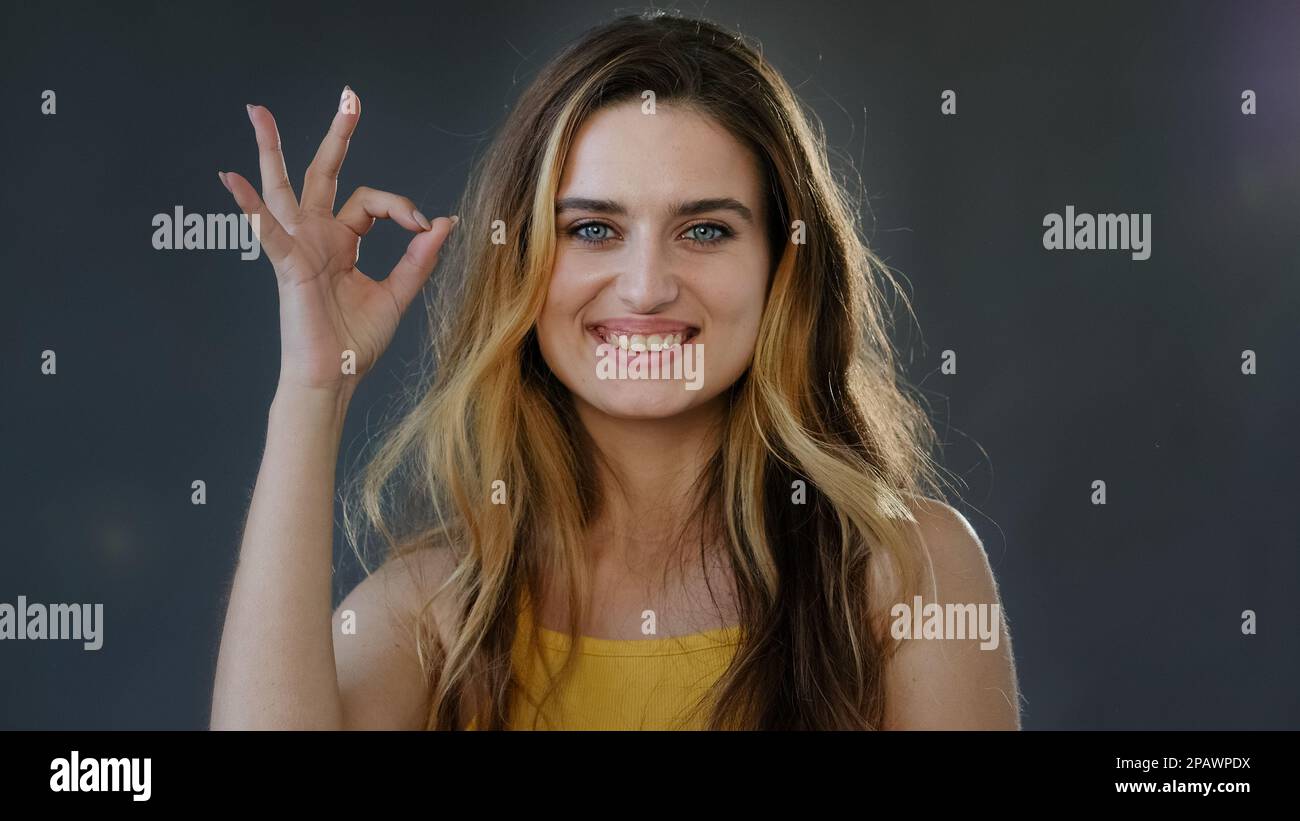 Femme portrait féministe réussie femme millénaire fille blonde modèle montre ok signe symbole tout OK bien bon parfait geste souriant Banque D'Images