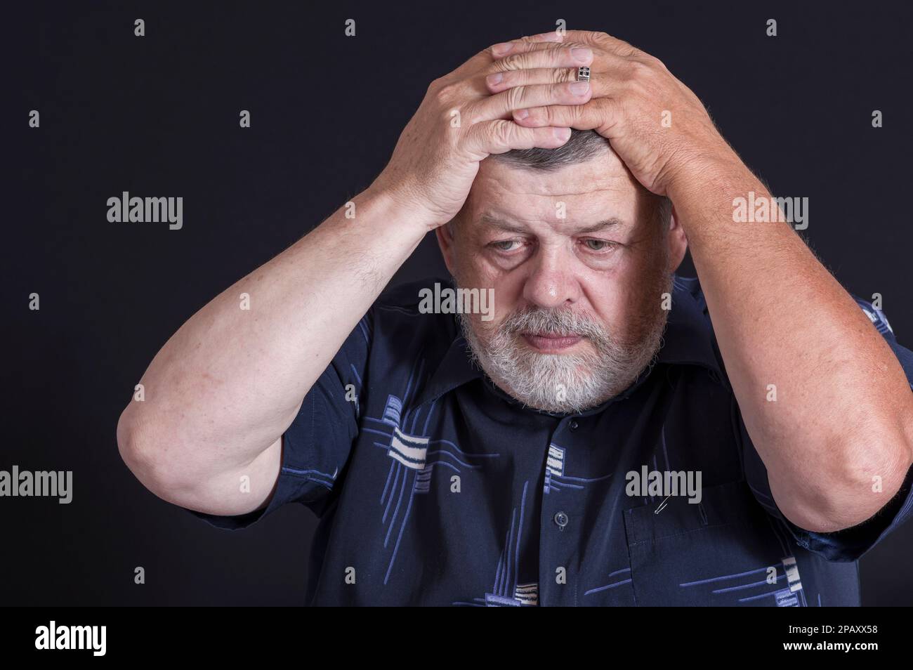 Beau portrait d'un homme âgé à barbe ukrainienne pensant aux problèmes de vie tout en étant assis dans l'obscurité Banque D'Images