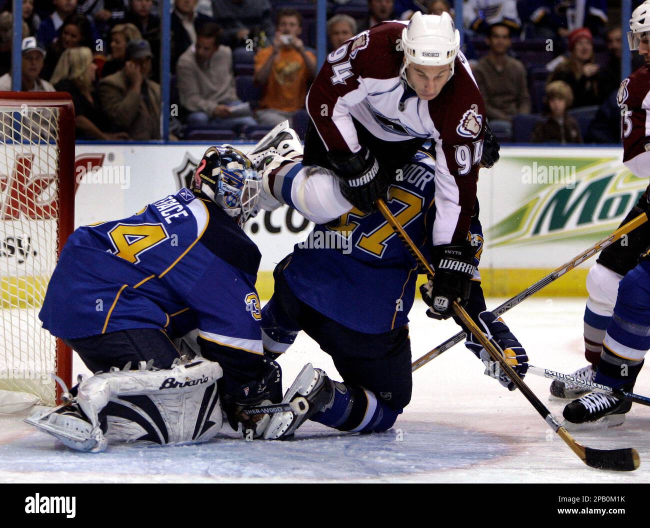 Colorado Avalanche's Ryan Smyth (94) leaps over St. Louis Blues' Bryce Salvador, bottom right, and St. Louis Blues goalie Manny Legace during the first period of an NHL hockey game Friday, Oct. 12, 2007, in St. Louis. (AP Photo/Jeff Roberson) Banque D'Images
