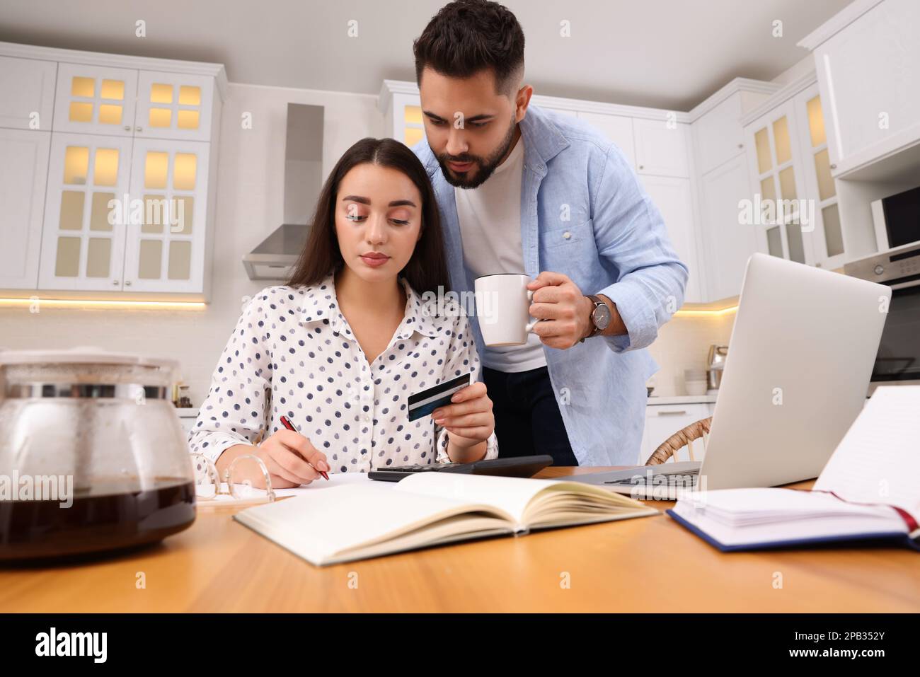 Jeune couple discutant du budget familial dans la cuisine Banque D'Images