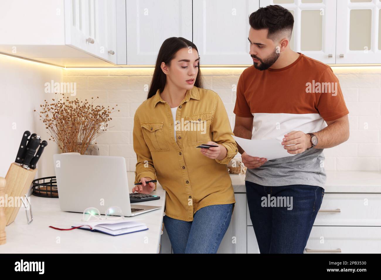 Jeune couple discutant du budget familial dans la cuisine Banque D'Images