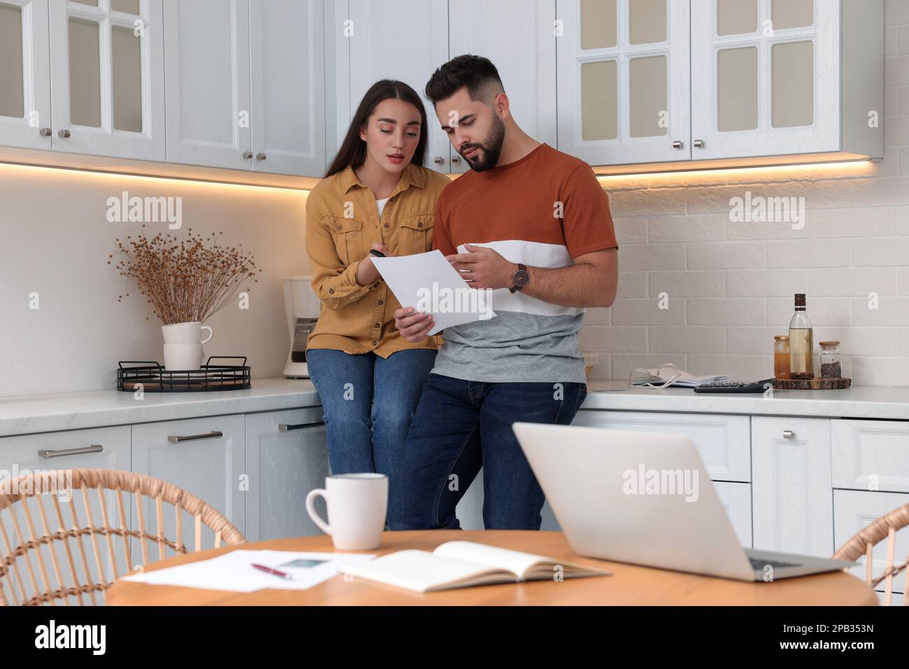 Jeune couple discutant du budget familial dans la cuisine Banque D'Images