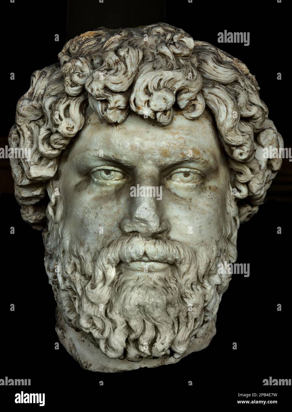 Tête de portrait d'Aelius César (peut-être Lucius Aelius Verus), une ancienne sculpture romaine de portrait en marbre datant de la période Antonin, IIe siècle après JC, basée sur un relief funéraire ou un dessin commémoratif. Le buste grandeur nature présente des boucles de cheveux dynamiques et épaisses et profondément percées et une barbe bouclée complète, exposée au Musée de l'Agora antique à Athènes, en Grèce. Banque D'Images