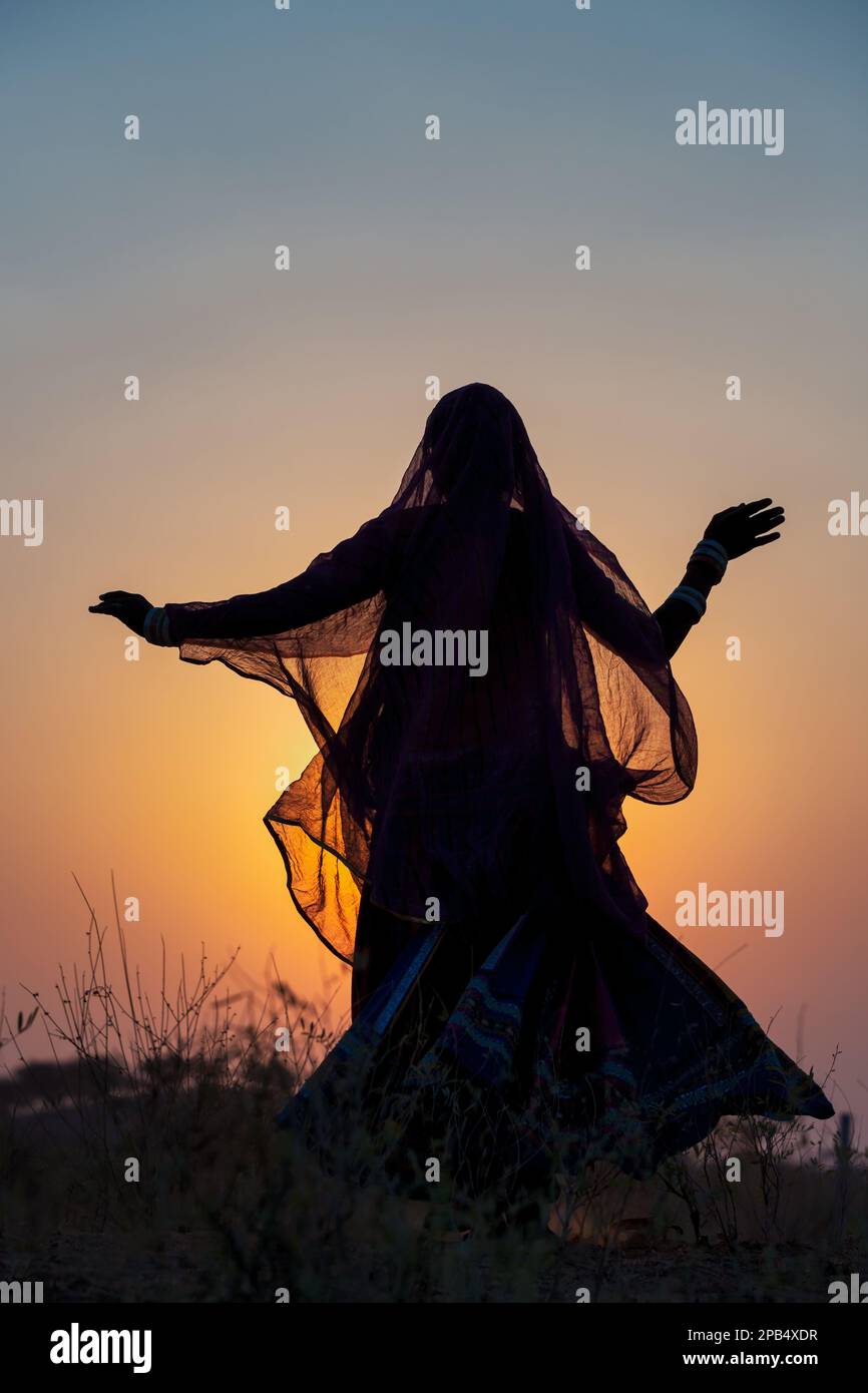 Coucher du soleil, la silhouette d'une femme dansant une danse traditionnelle, Pushkar, Rajasthan, India Banque D'Images