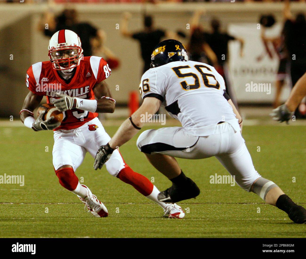 Louisville receiver Harry Douglas tries to avoid Murray State defender Tyler Sinclair after catching a pass during the first half of their college football game in Louisville, Ky., Thursday, Aug. 30, 2007. (AP Photo/Garry Jones) Banque D'Images