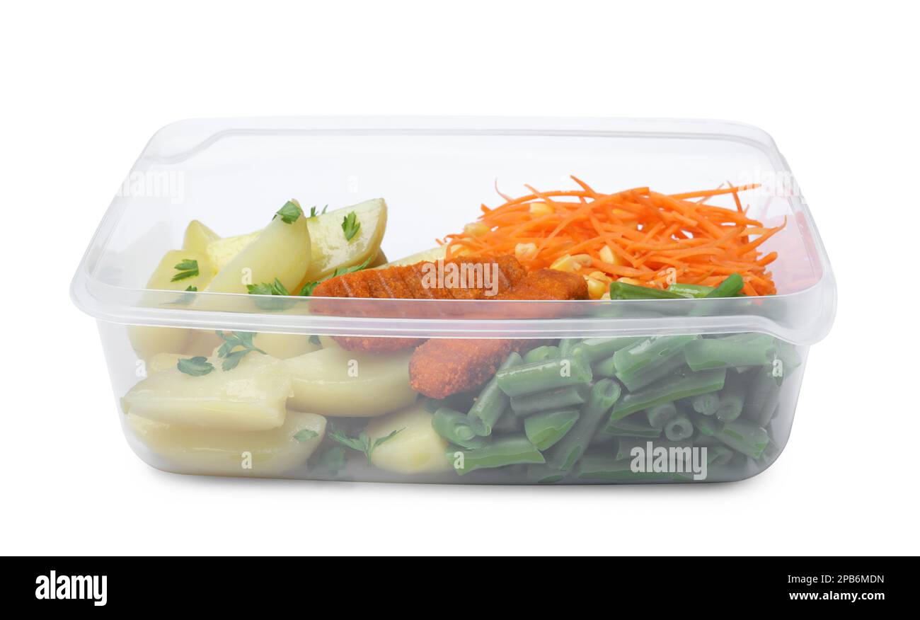 Pommes de terre savoureuses avec des côtelettes et des légumes dans un récipient en plastique isolé sur blanc Banque D'Images