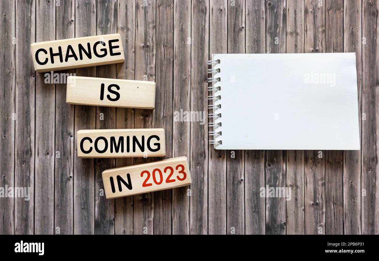 Des changements seront apportés en 2023. Changements conceptuels de mots qui se produiront en 2023 sur des blocs de bois à côté d'un bloc-notes pour l'écriture. Magnifique backgrou en bois Banque D'Images