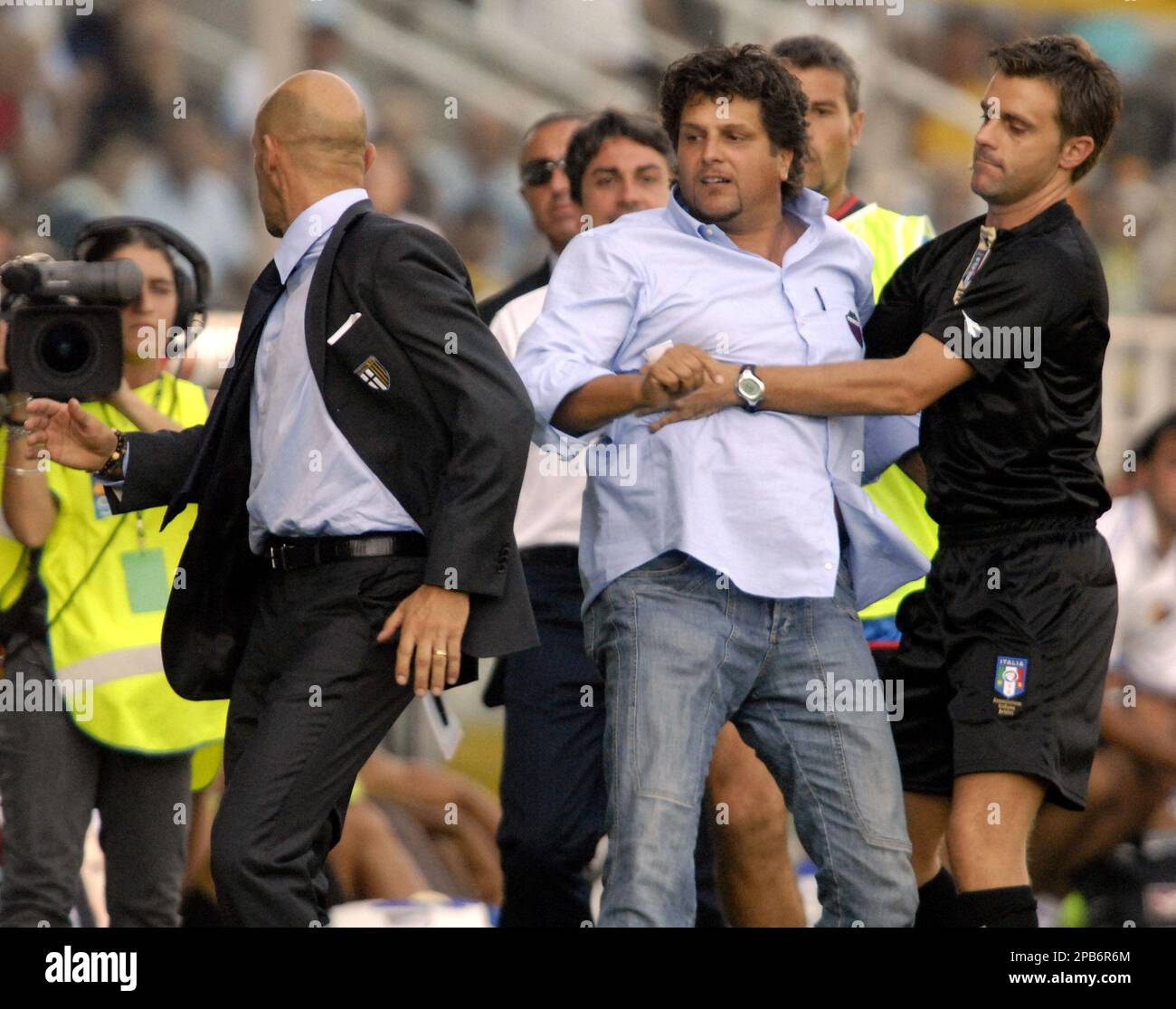 Catania coach Silvio Baldini, right, is restrained by an assistant referee after kicking Parma coach Domenico Di Carlo during an Italian first division soccer match between Parma and Catania, at the Parma stadium, Italy, Sunday, Aug. 26, 2007. (AP Photo/Luigi Vasini) Banque D'Images