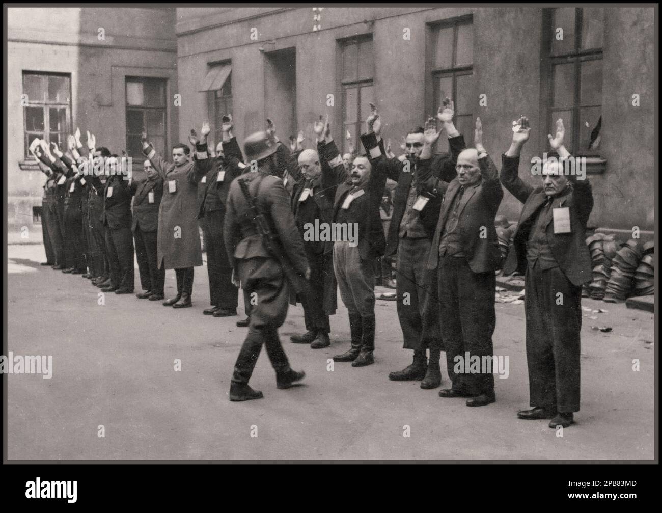 Soulèvement du ghetto de Varsovie : photographie des troupes SS nazies arrêtant les chefs de département juifs de l'usine de casques Brauer. Le « magasin » Brauer, de Herman Brouer, fabriquait des casques pour l'armée allemande, était situé au 28-38 rue Nalewki et employait 2 000 personnes. Leurs ouvriers étaient probablement parmi les derniers Juifs à être déportés du ghetto. Avec le déclenchement du soulèvement le 19 avril 1943, Hermann Brauer promit aux gestionnaires juifs qui n'étaient pas allés se cacher que l'usine continuerait à fonctionner et leur demanda de venir travailler. Varsovie Pologne 1943 Banque D'Images