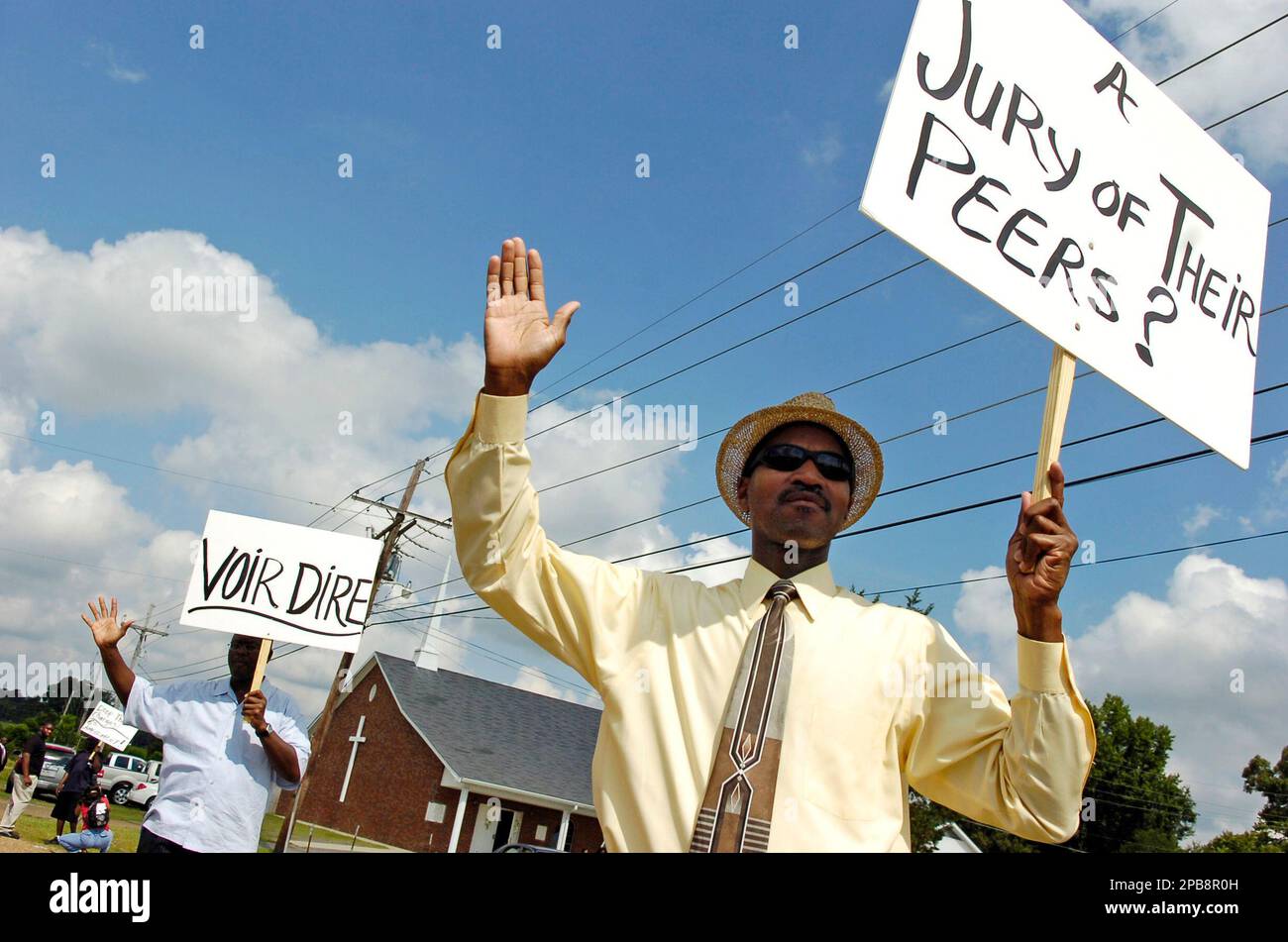 Roy Higgins, right, and Frederick Jones carry signs in support of six