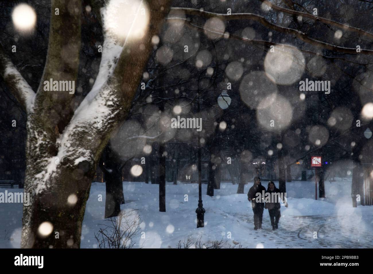 Moscou, Russie. 12th mars 2023. Les gens marchent à travers un parc de soirée dans un quartier résidentiel de Moscou pendant une forte chute de neige, Russie Banque D'Images