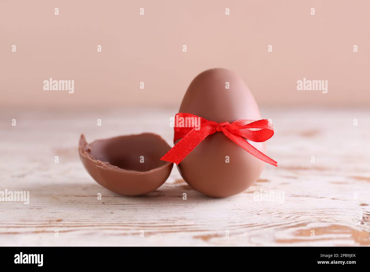 Oeuf de Pâques au chocolat attaché avec ruban sur une table en bois sur  fond marron Photo Stock - Alamy