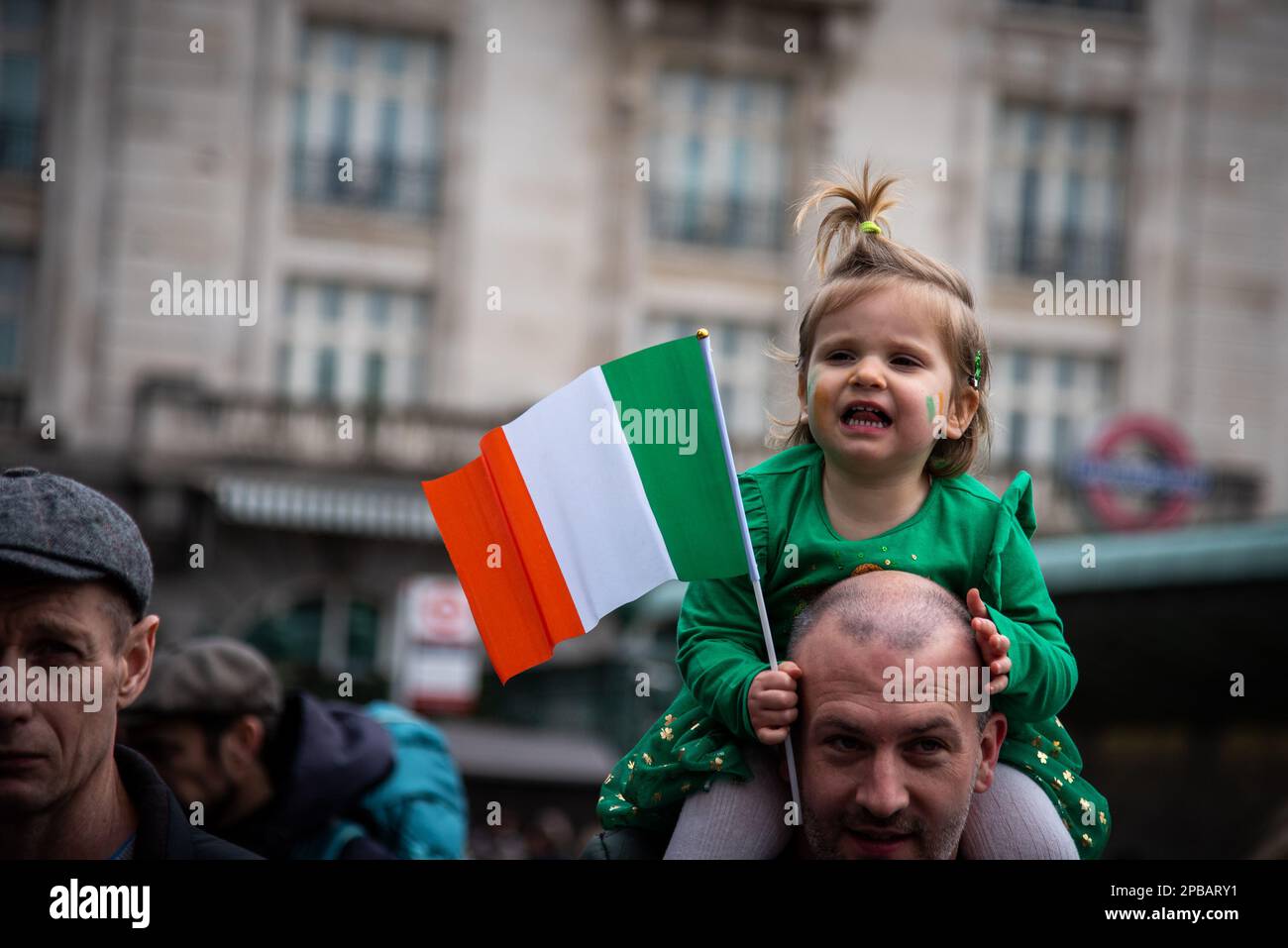 Londres, Royaume-Uni. 12th mars 2023. Un jeune spectateur au sommet des épaules de son père profite de la parade et du festival de la St Patrick dans le centre de Londres. Le shindig annuel du maire est devenu un point fort du calendrier culturel de Londres, alors que les Londoniens et les visiteurs s'unissent pour célébrer la grande contribution des Irlandais à la ville. Plus de 50 000 personnes devaient se joindre à la procession annuelle des groupes irlandais de marche, des troupes de danse et de l'infanterie. Crédit : SOPA Images Limited/Alamy Live News Banque D'Images