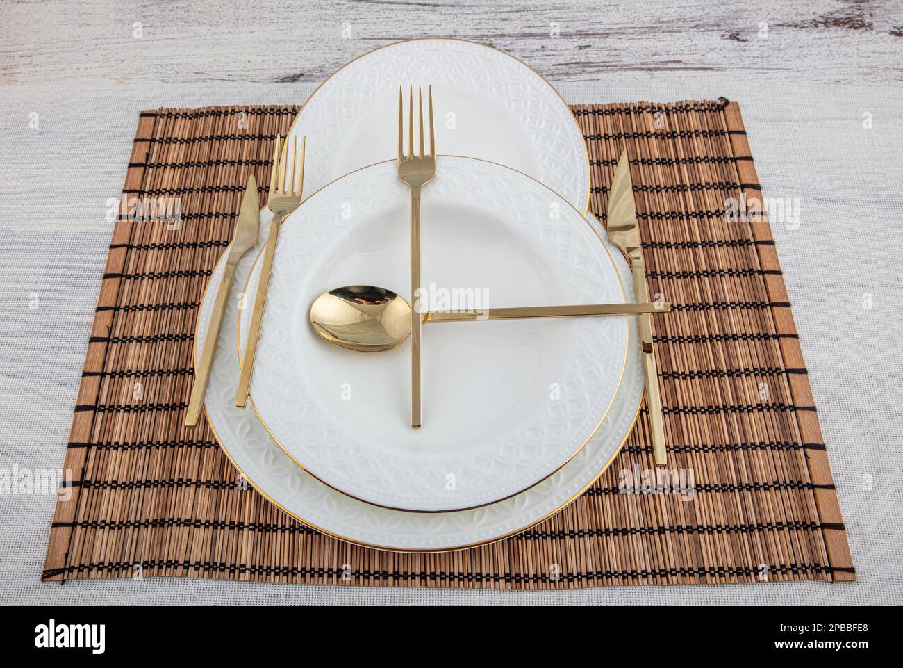 Assiettes et ustensiles, assiette, bol et couverts dorés en osier américain  servant sur la table à manger, vue latérale. Vaisselle moderne en  céramique, couverts sur le t Photo Stock - Alamy