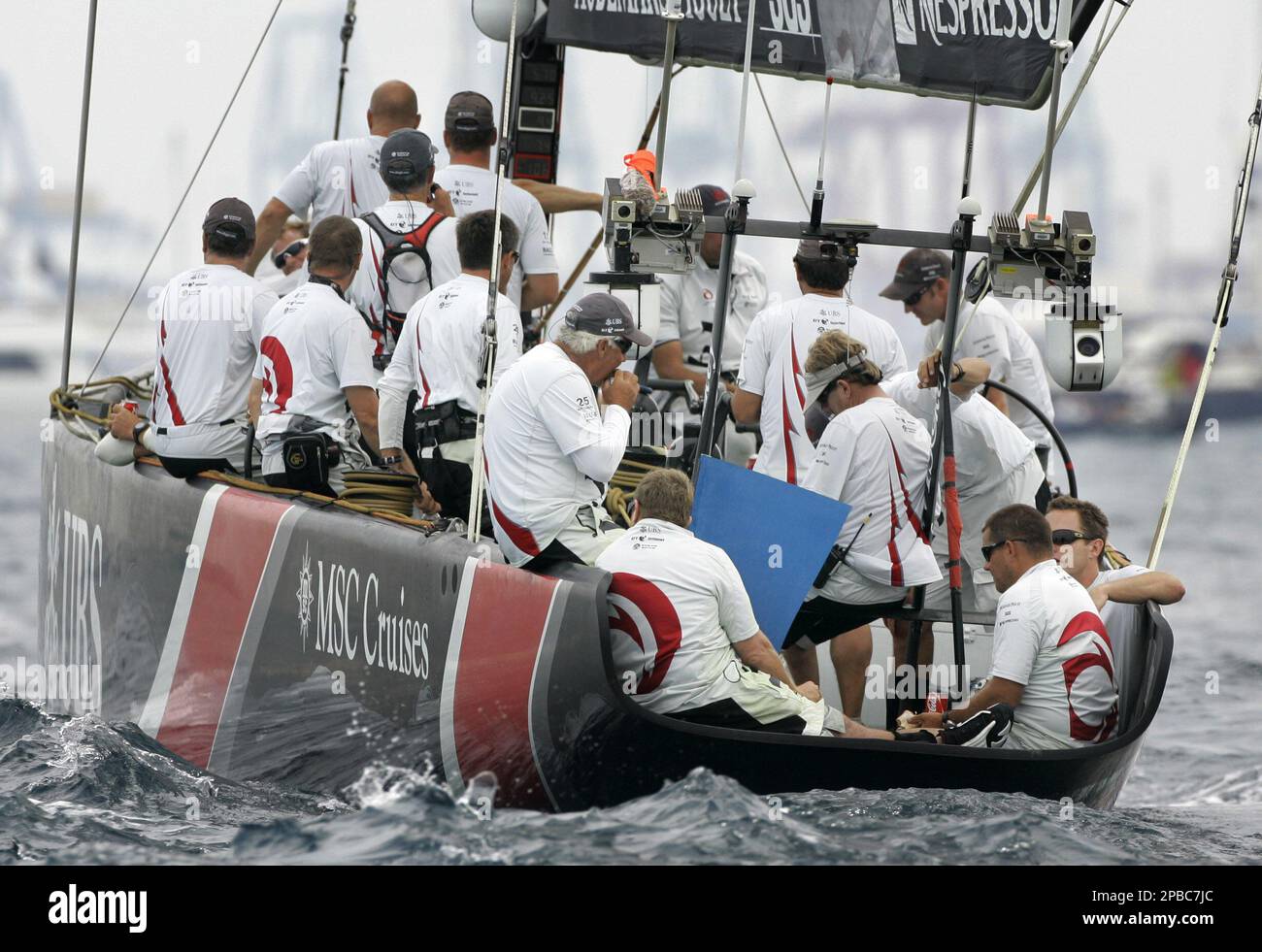 Crew members of Swiss Defender Alinghi wait in vain for wind to sail before race seven of the 32nd America's Cup off the coast of Valencia, Spain, Sunday, July 1, 2007. Race seven was cancelled due to lack of wind. (AP Photo/Fernando Bustamante) Banque D'Images