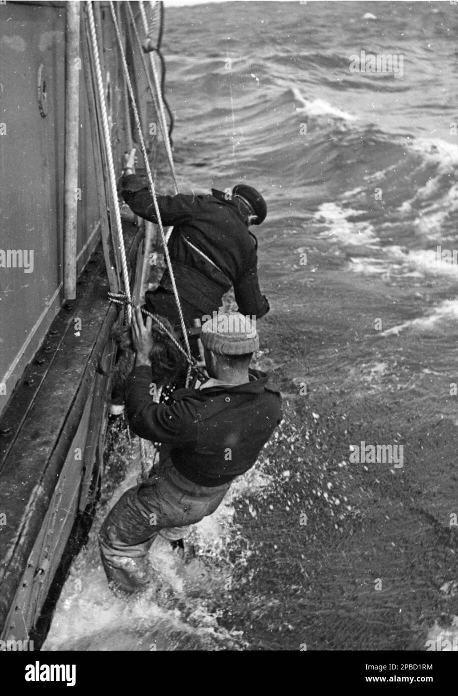 Photographie de l'expédition par Laurence le Guay montrant William Cook (arrière-plan) et un autre HMAS Wyatt EARP Crewman Fotherin lors de leur voyage en Antarctique, 1947 Banque D'Images