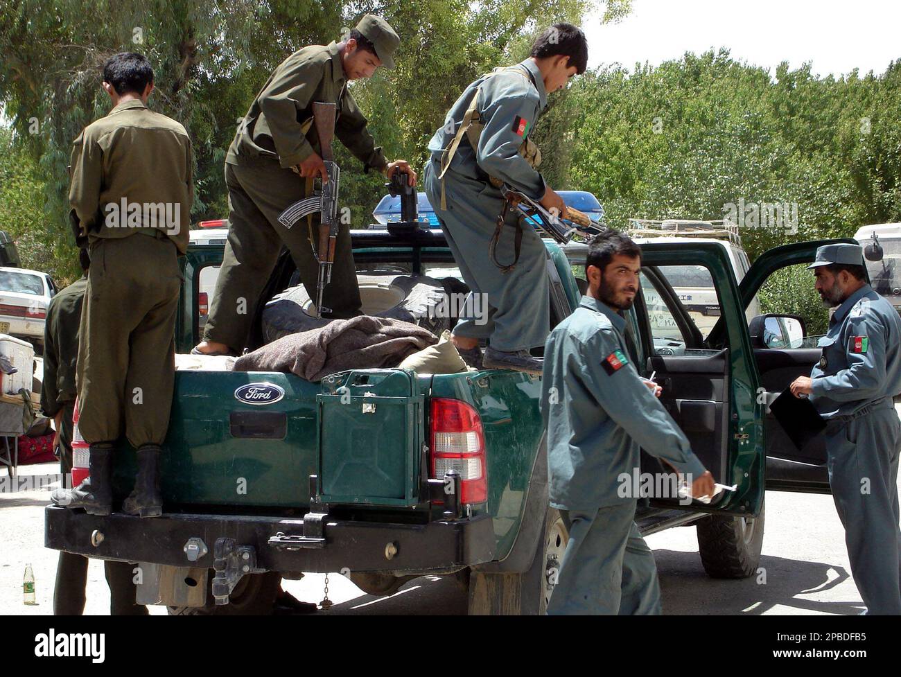Afghan police men get off their vehicle, as a remote-controlled bomb exploded near a police vehicle in Nad Ali district of southern Helmand , south of Kabul, Afghanistan, Saturday, June 16, 2007. A remote-controlled bomb exploded near a police vehicle on patrol in Nad Ali district of southern Helmand province on Saturday, wounding five police, said Bahram Aka, who was among those hurt. He spoke from his hospital bed in the provincial capital Lashkar Gah. (AP Photo/Abdul Khaleq) Banque D'Images